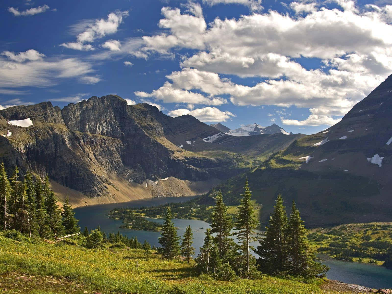 Montana 桌布 壁紙 — 寧靜的高山湖泊坐落在崎嶇的山脈之間，藍天白雲，景色宜人。