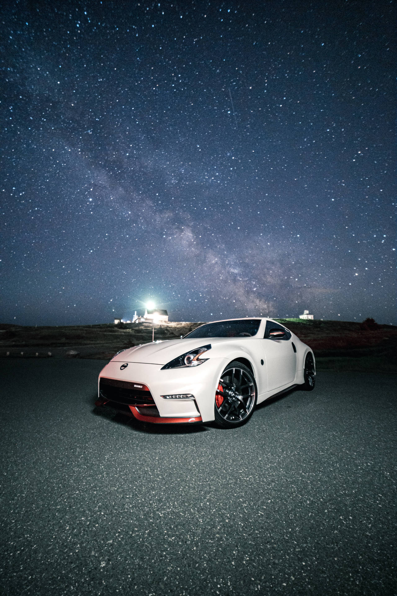 白色跑車停放在星空下，銀河可見。