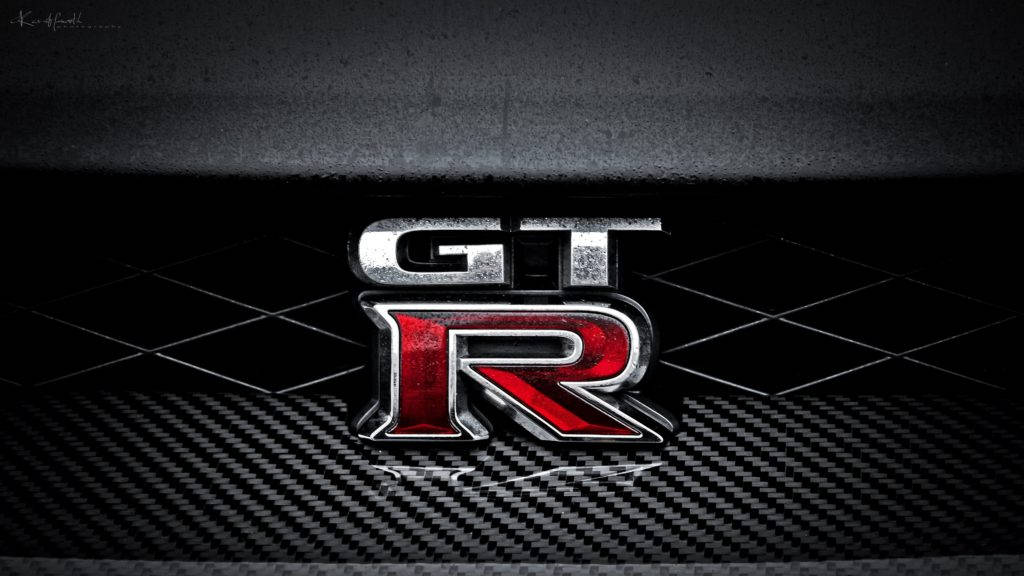 碳纖維表面上的 GTR 標誌，帶有金屬紅色和銀色飾面。