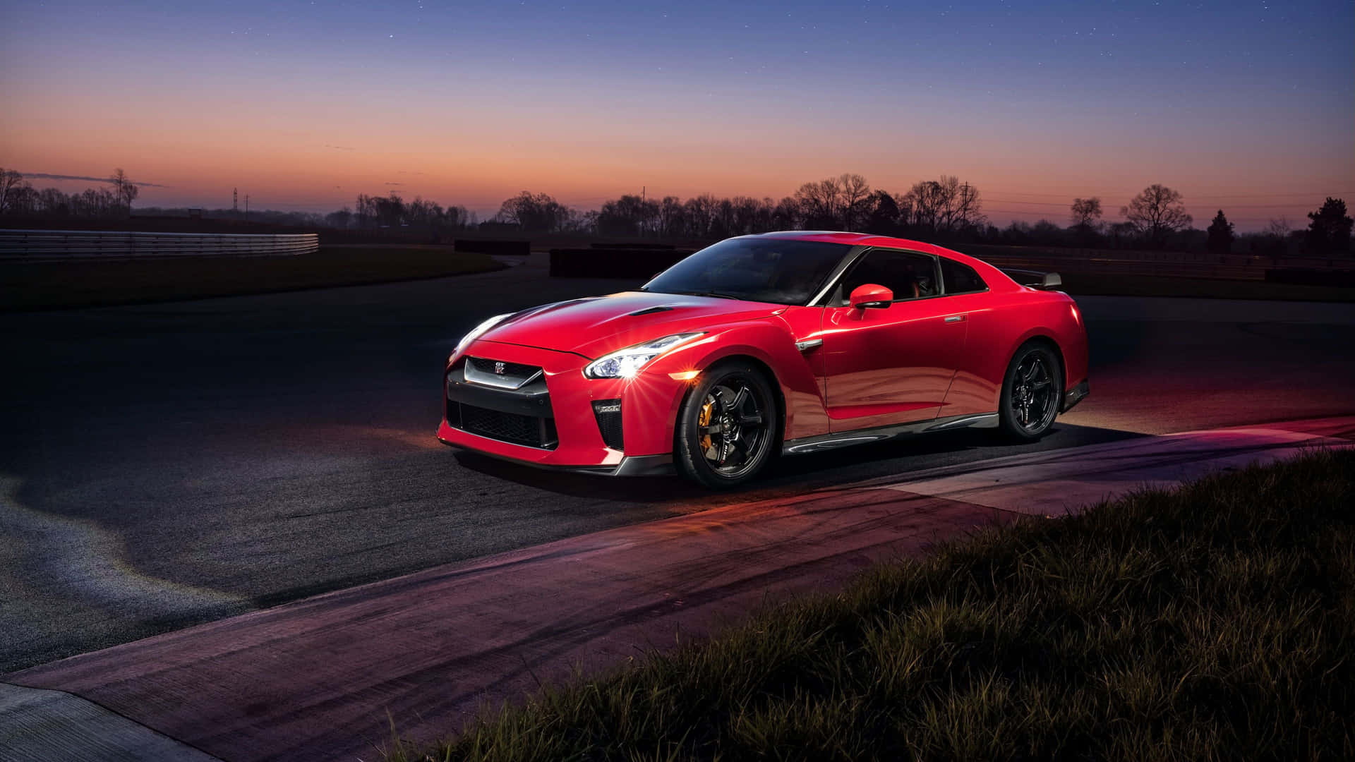 暮色中賽道上可見星星的紅色日產GT-R