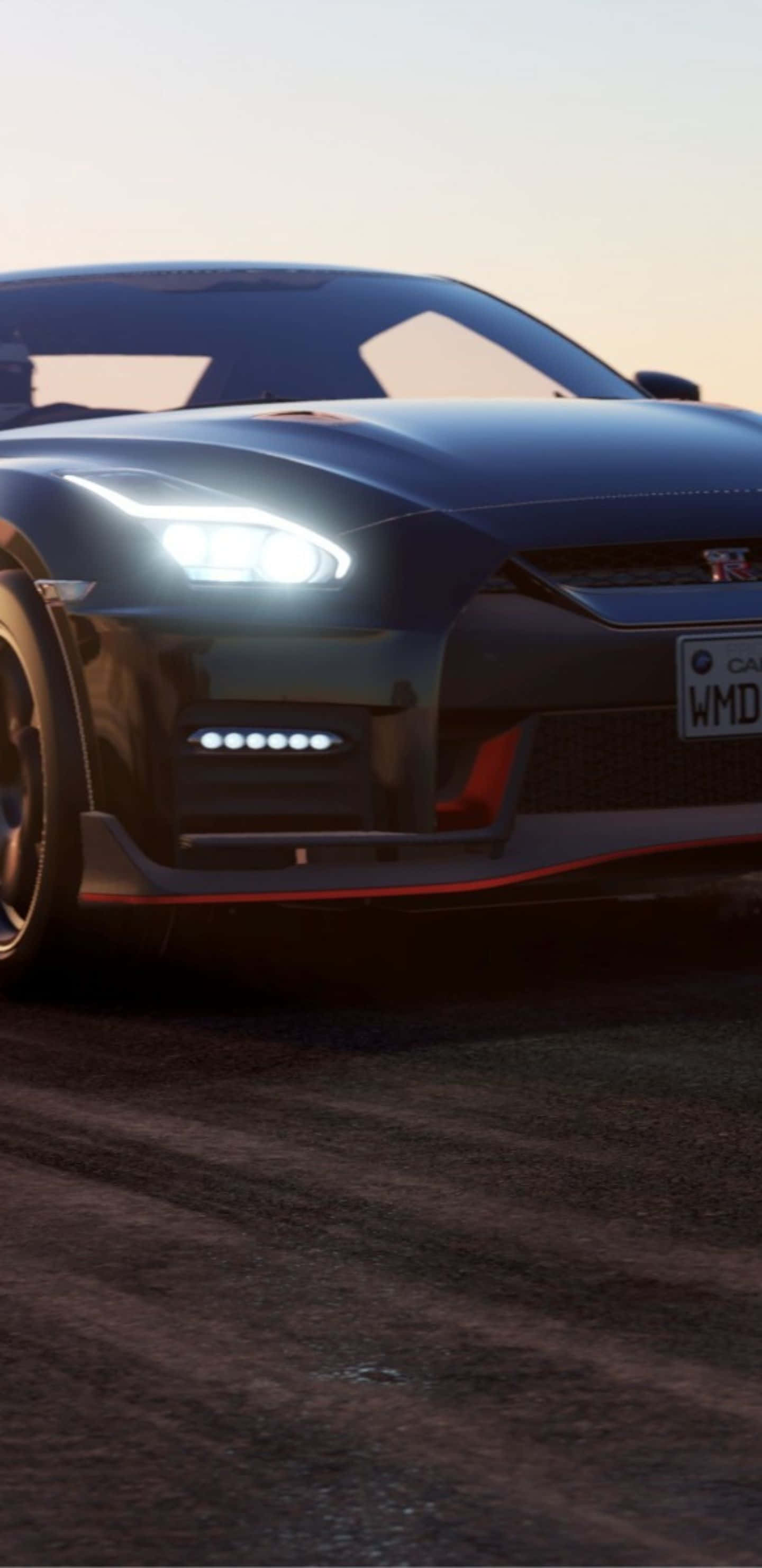Nissan GTR R35 - 賽道剪影壁紙 壁紙 — 一架時尚黑色跑車，配備發光車頭燈和紅色點綴，停泊在日落時分的塵土路上。