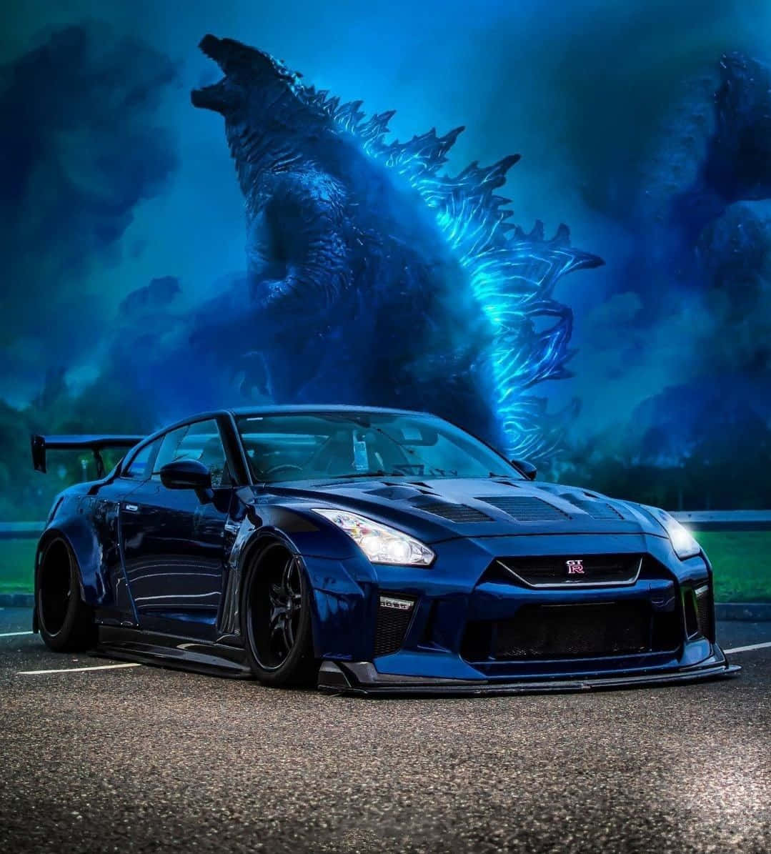 藍色哥吉拉 Nissan R35 GT-R 車圖 壁紙 — 一架時尚的藍色日產GT-R跑車停在路上，身後暴風雨般的藍色天空中，巨大的發光哥斯拉若隱若現。