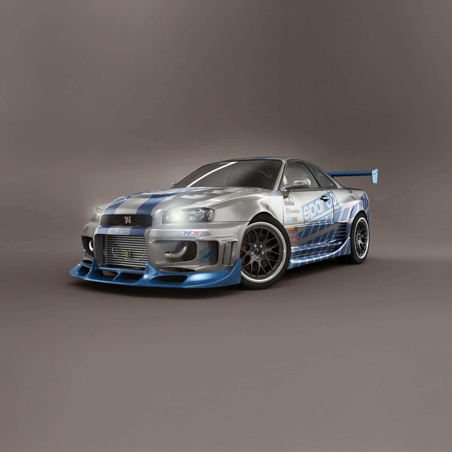銀色和藍色的日產Skyline GT-R賽車，帶有空氣動力學套件和贊助商貼紙，在工作室中。