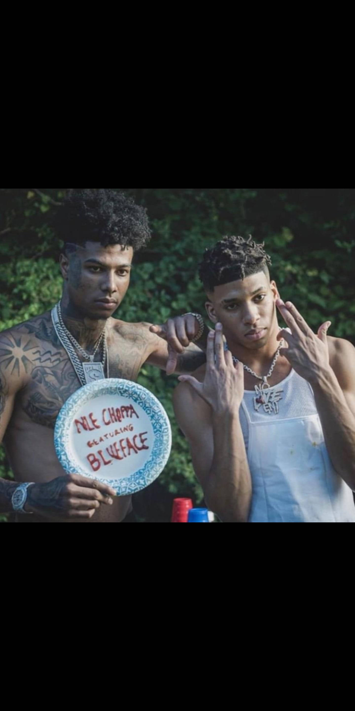 藍臉 與NLE CHOPPA 壁紙 — 兩名紋身男子在戶外擺姿勢，其中一人手持飛盤，上面有「DILL CHOPPA FEATURING BLUEFACE」字樣。