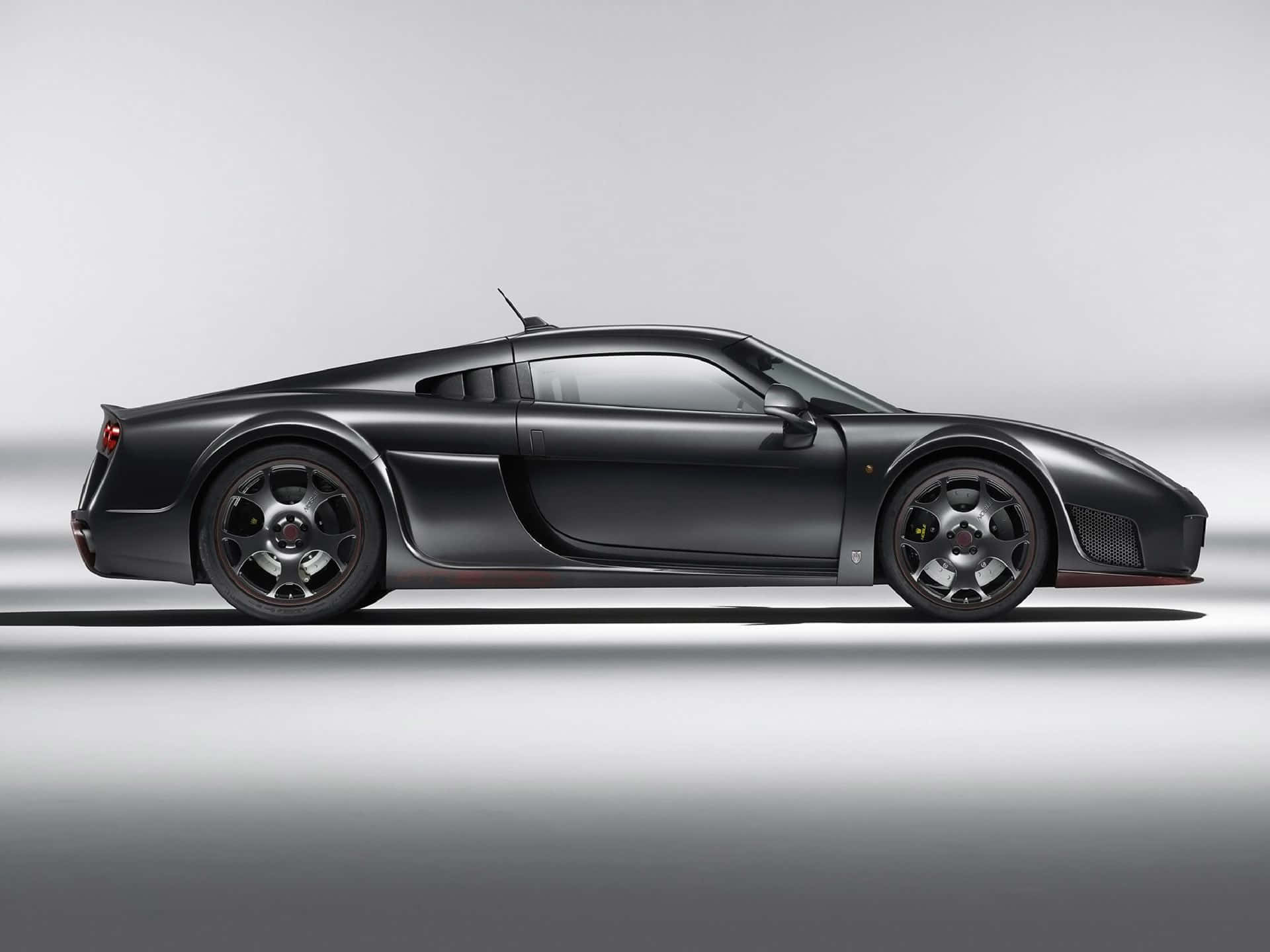 「勇猛而莊嚴的黑色 Noble M600」 壁紙 — 一輛時尚的霧面黑色布加迪威龍跑車在極簡灰色工作室背景下的側面展示。