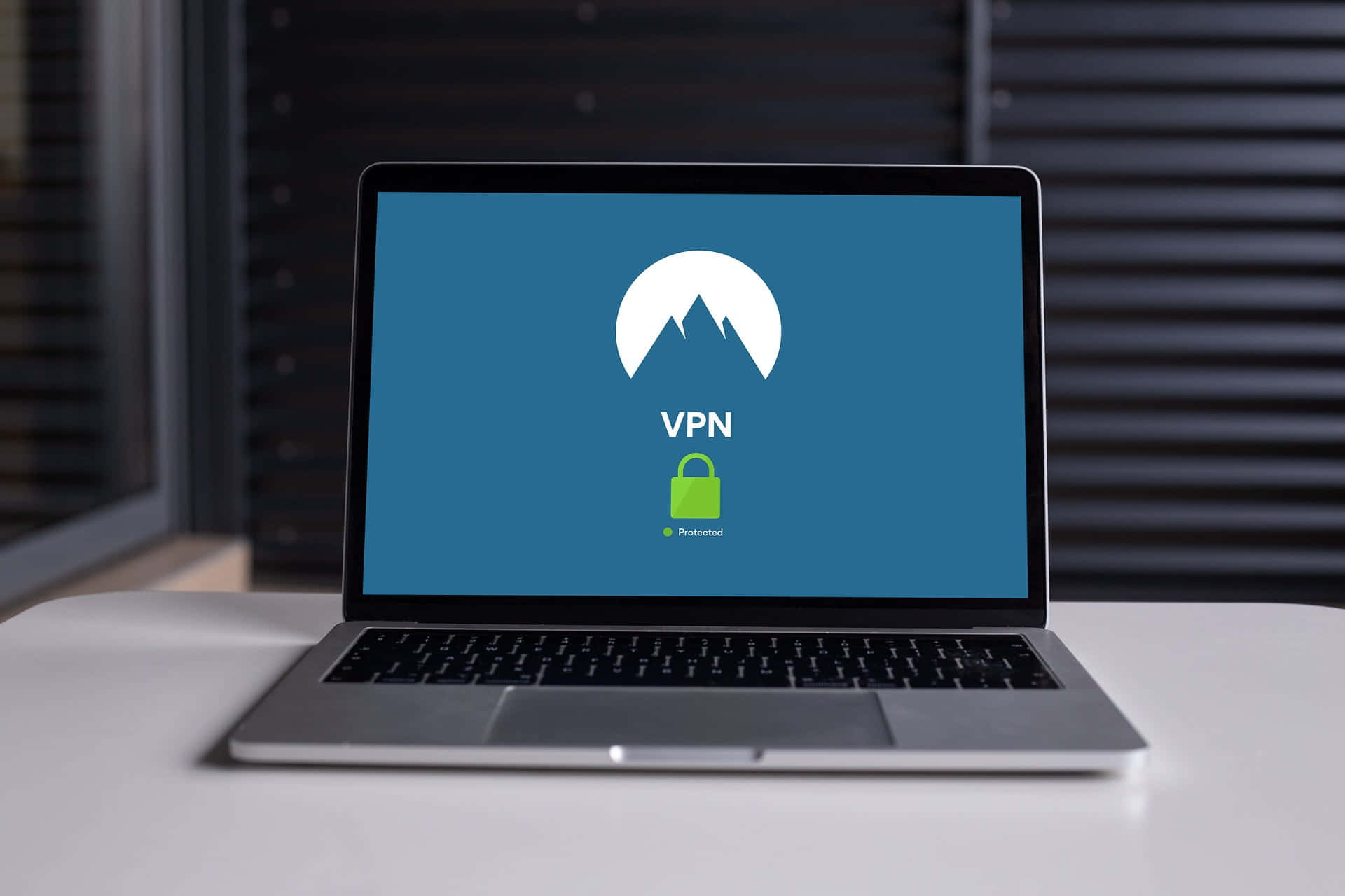 筆記型電腦顯示VPN保護，帶有山脈標誌和綠色鎖圖示。