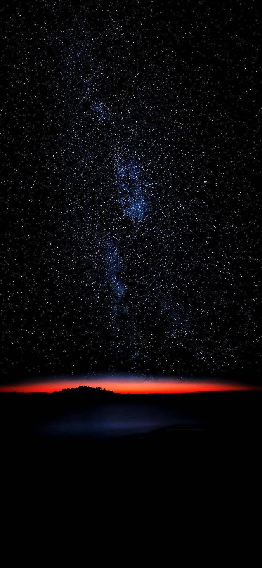繁星點點的夜空，紅色地平線在黑暗的大地輪廓上方