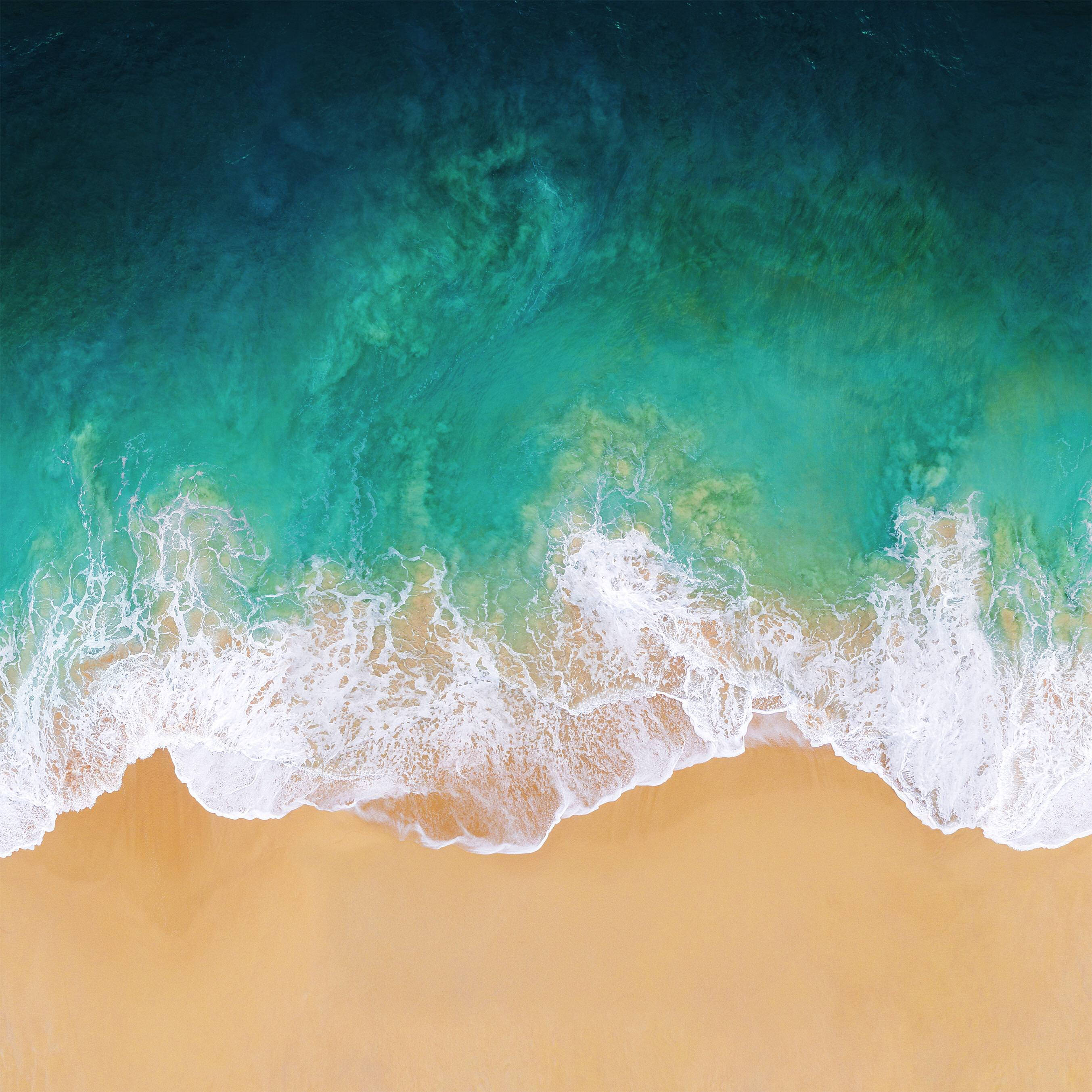 Note 8 海灘波浪 壁紙 — 從高空俯瞰，綠松石色的海浪拍打著金色沙灘，呈現出充滿活力的海岸景色。