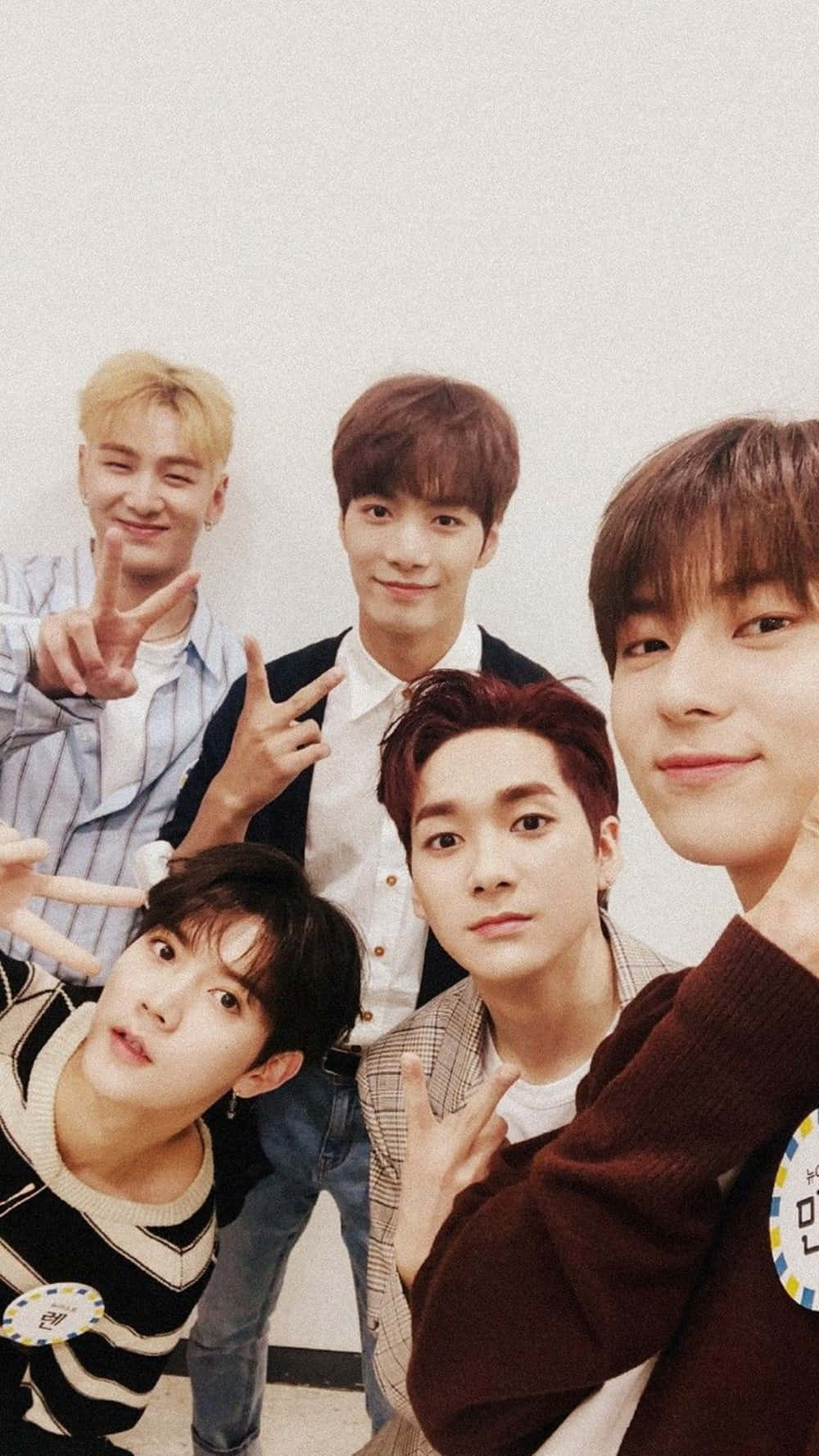 NU'EST — K-pop 音樂界的強大力量 壁紙 — 五名身穿休閒服的年輕男子緊密地站在一起，對著純白牆壁做出和平手勢。