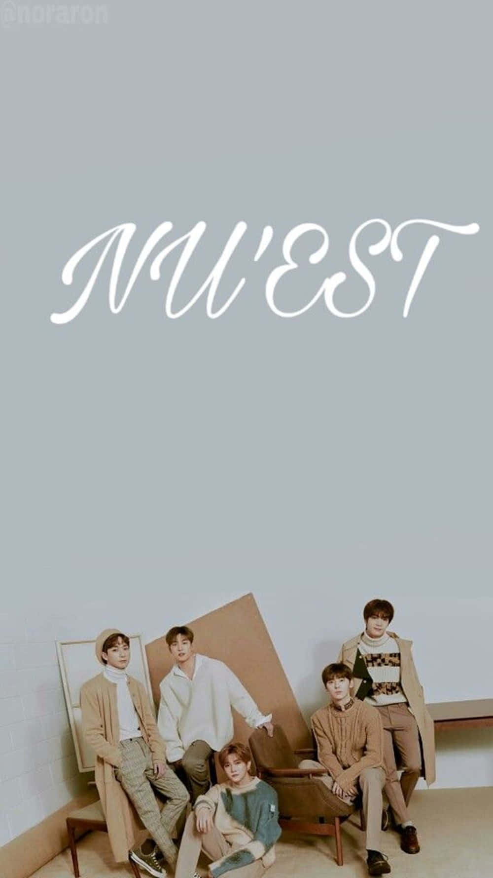 Nuest K-pop 男子團體中性風格 壁紙 — 五位年輕男子身穿協調的米色和白色服裝，隨意地坐在木製家具上，背景是純淺灰色牆壁，上方有白色的「NU'EST」字樣。