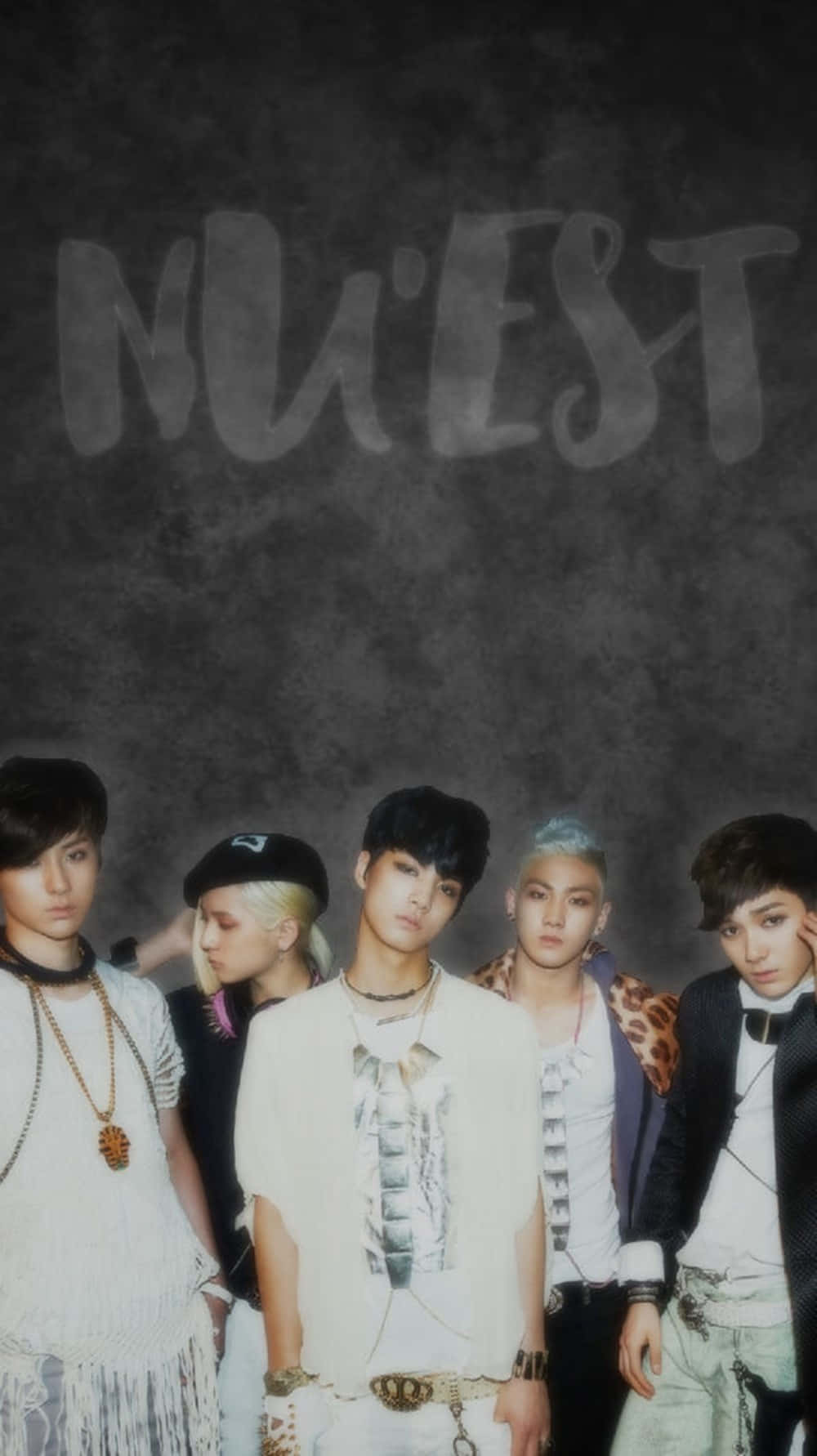 Nuest K-pop 男子團體暗黑嘻哈風格 壁紙 — 五位時尚年輕男子穿著前衛服裝，在深色紋理牆前擺姿勢，牆上有「NU'EST」塗鴉。