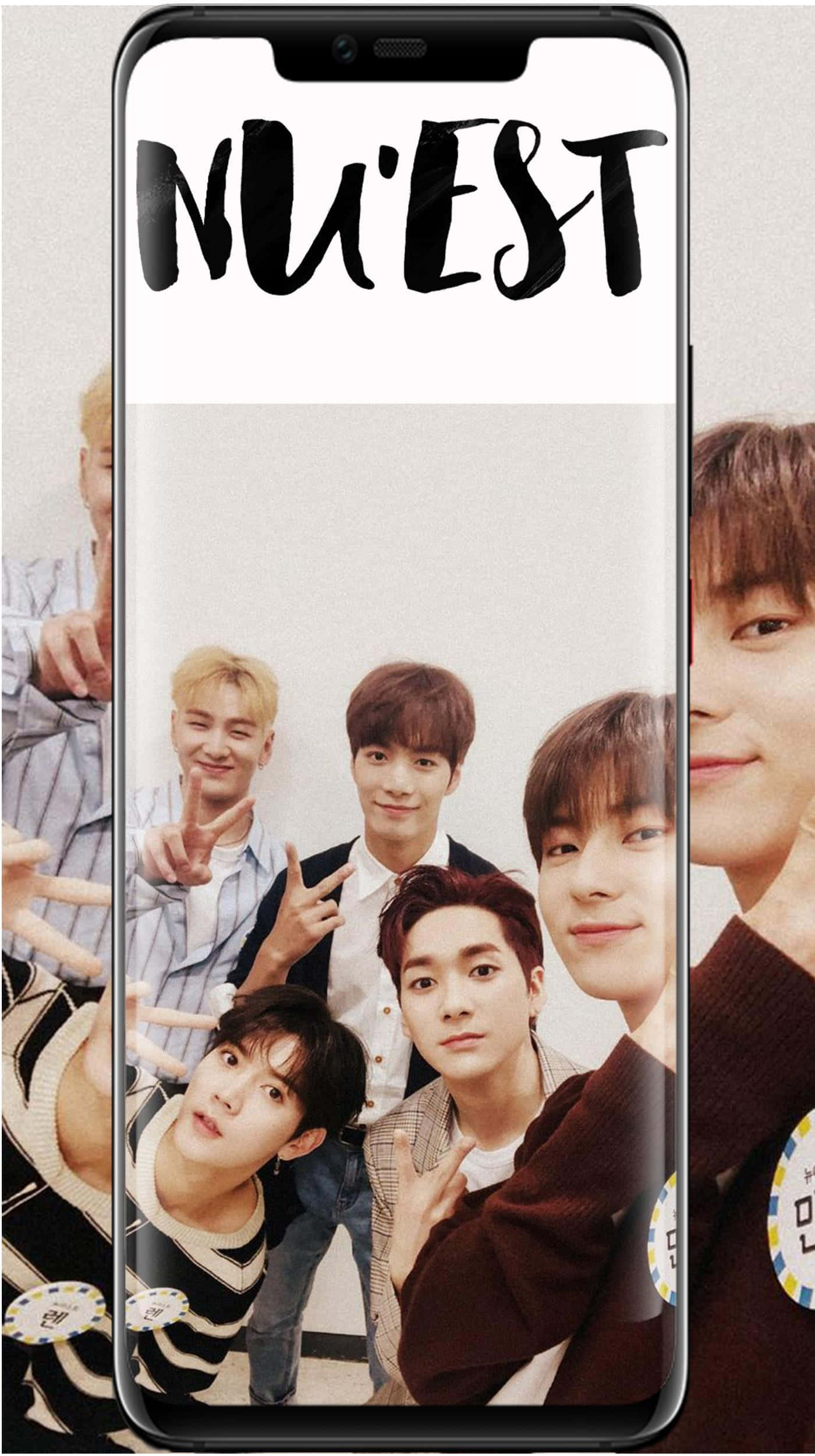 Nuest K-pop 男子團體手機壁紙模擬 壁紙 — 一部智能手機顯示K-pop組合NU'EST的團體照，成員在純色背景前開心地擺姿勢。