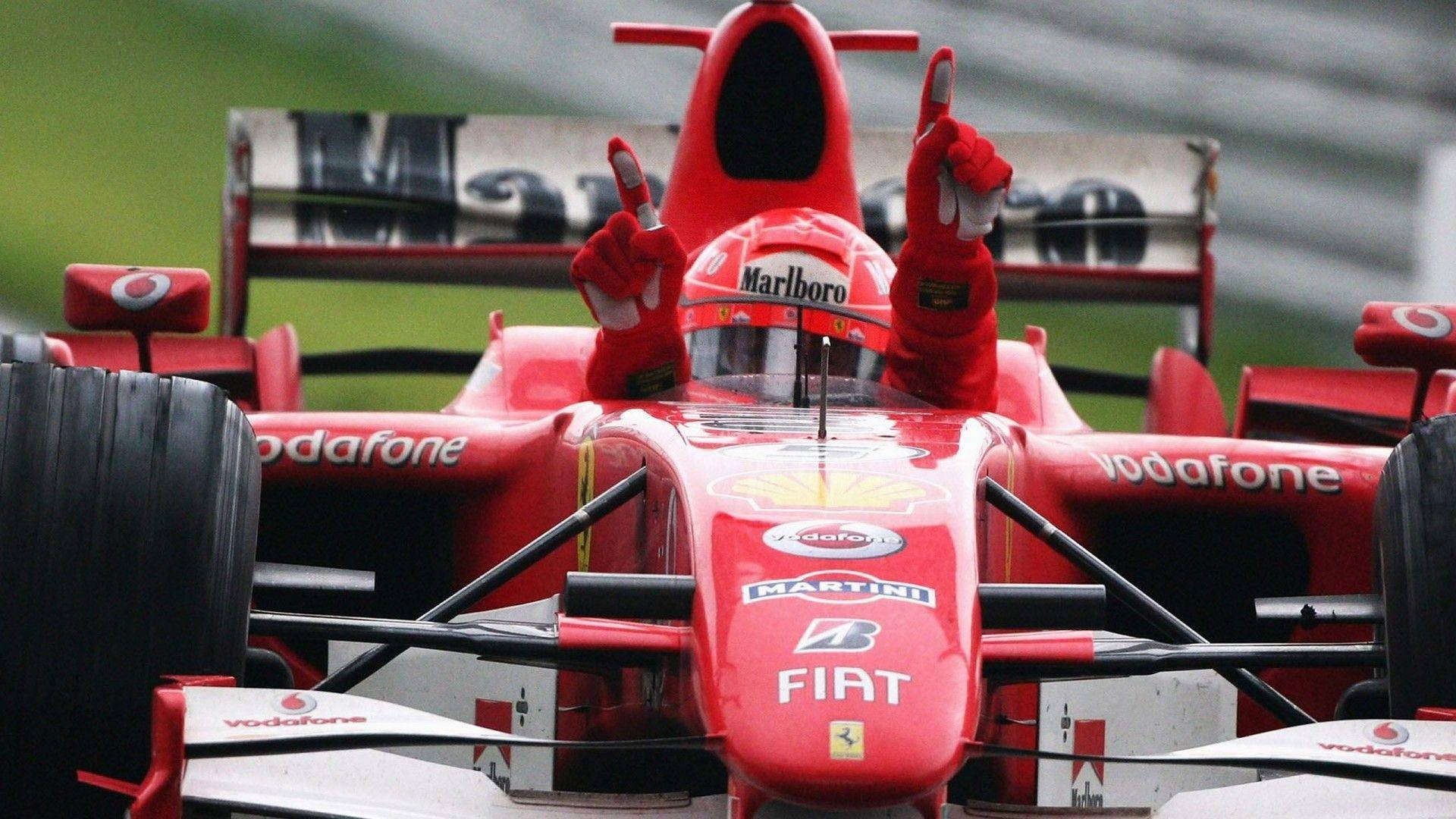 紅色法拉利F1車手在潮濕賽道上高舉雙手慶祝勝利。
