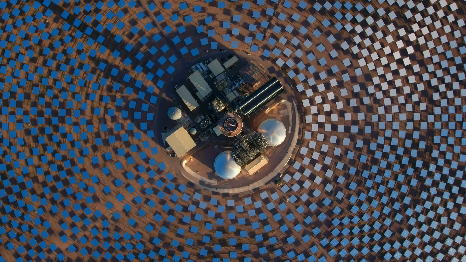 NV Energy太陽能發電塔 壁紙 — 從空中俯瞰一座太陽能發電廠，數千塊藍色鏡子圍繞中央塔樓排列成同心圓。
