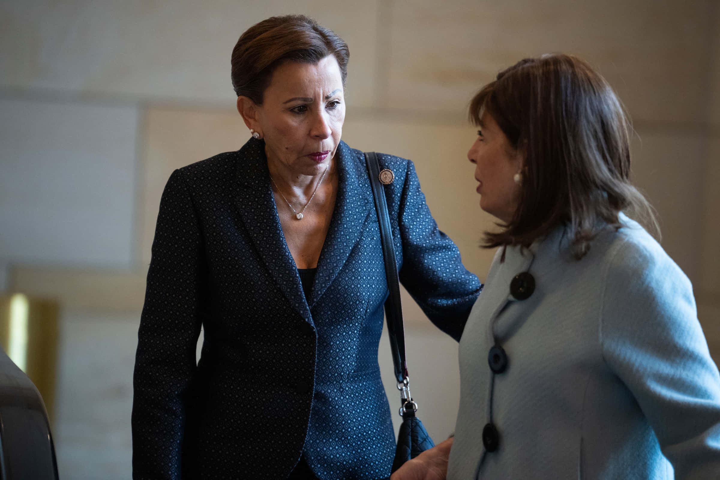 Nydia Velázquez 與工作人員對話 壁紙 — 兩位穿著專業服裝的女性在室內進行嚴肅對話，表情專注。