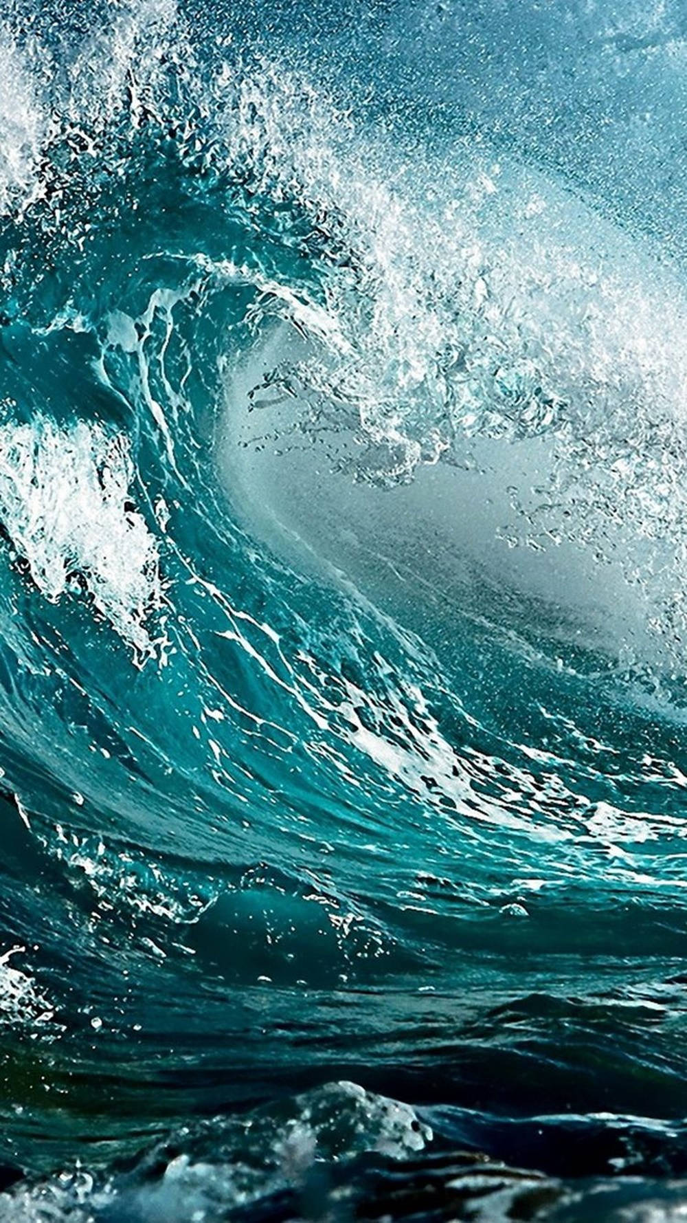 一道巨大的捲曲海浪，帶有綠松色海水和白色泡沫。