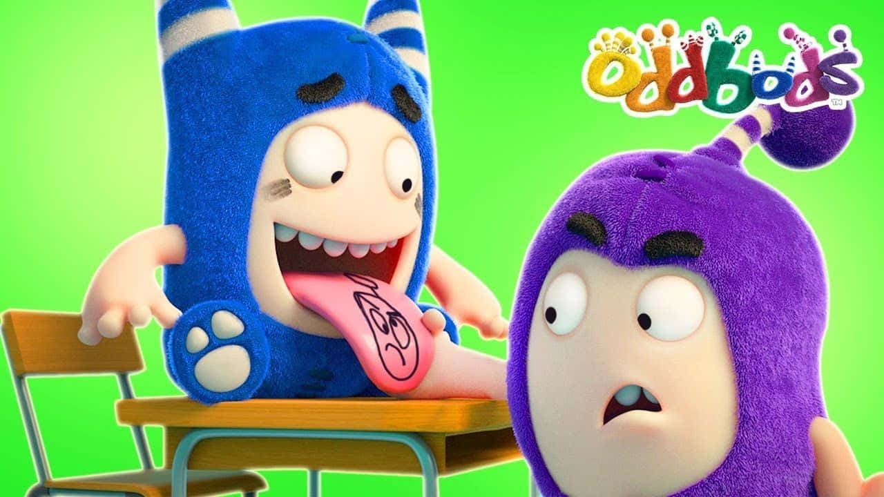 兩個Oddbods角色，一個藍色伸舌頭，一個紫色震驚地看著書桌。