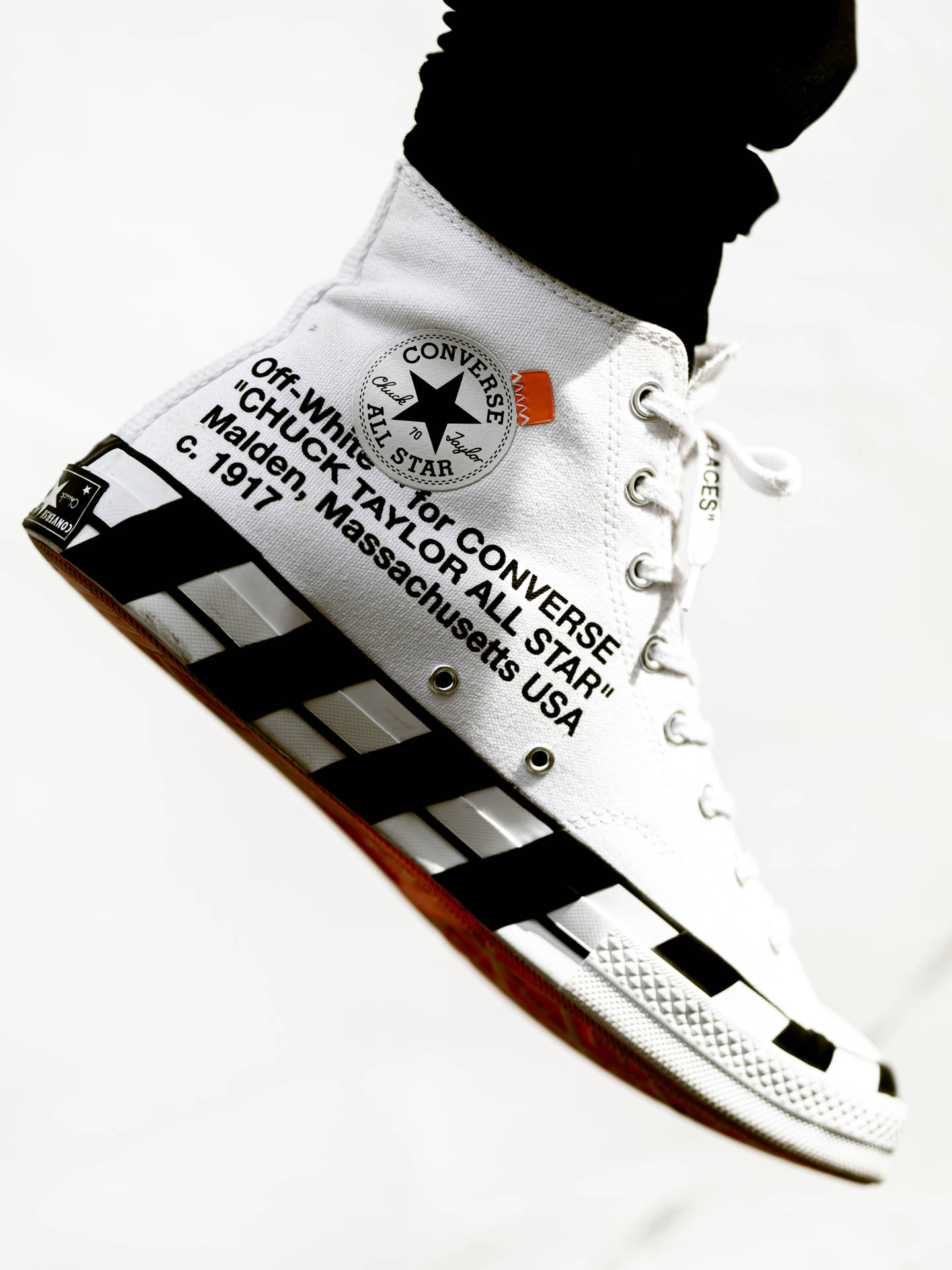 白色高筒運動鞋，帶有黑色拍板條紋和文字，詳細說明 Off-White 合作。