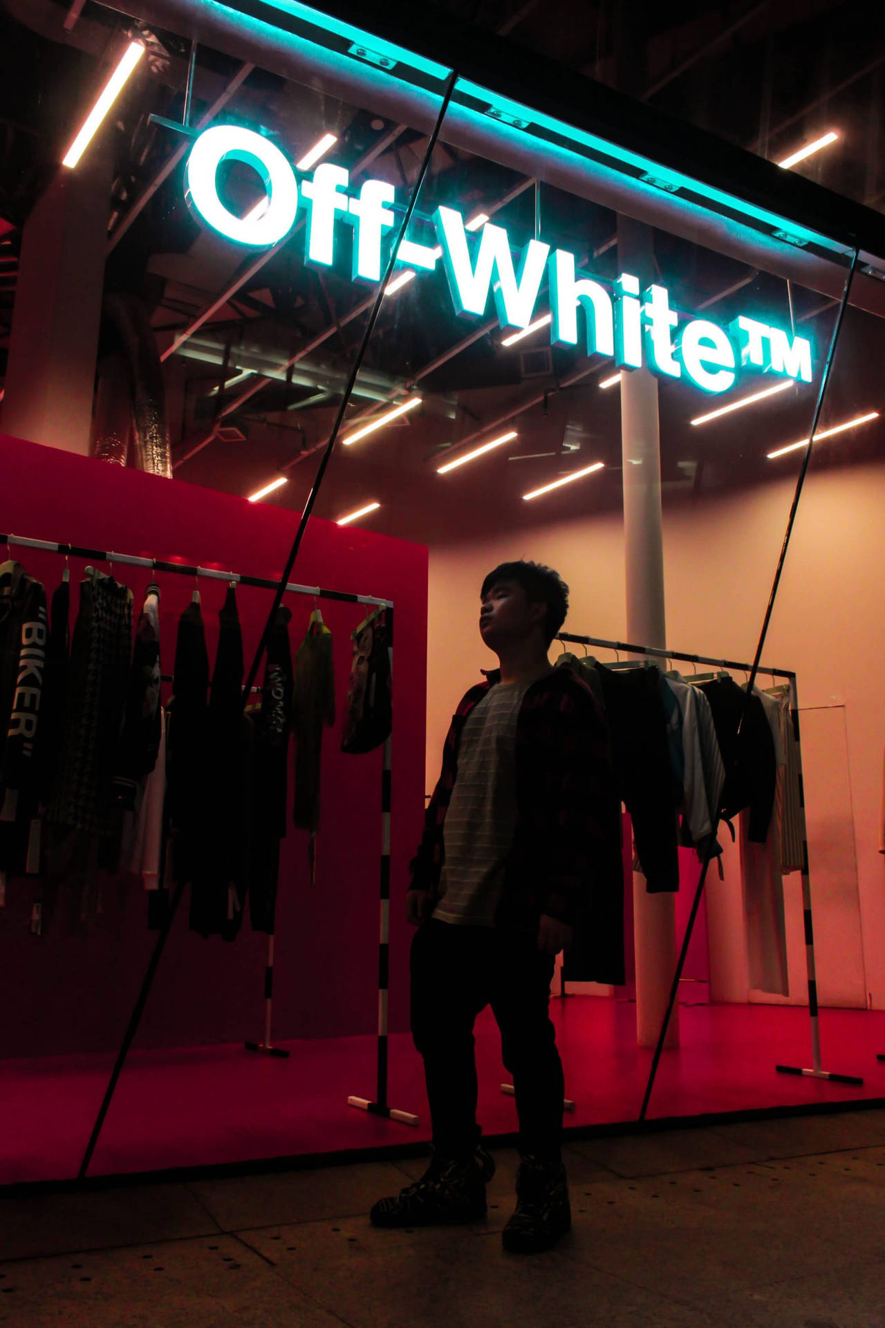 站在 Off-White 商店前，有霓虹燈和衣架。