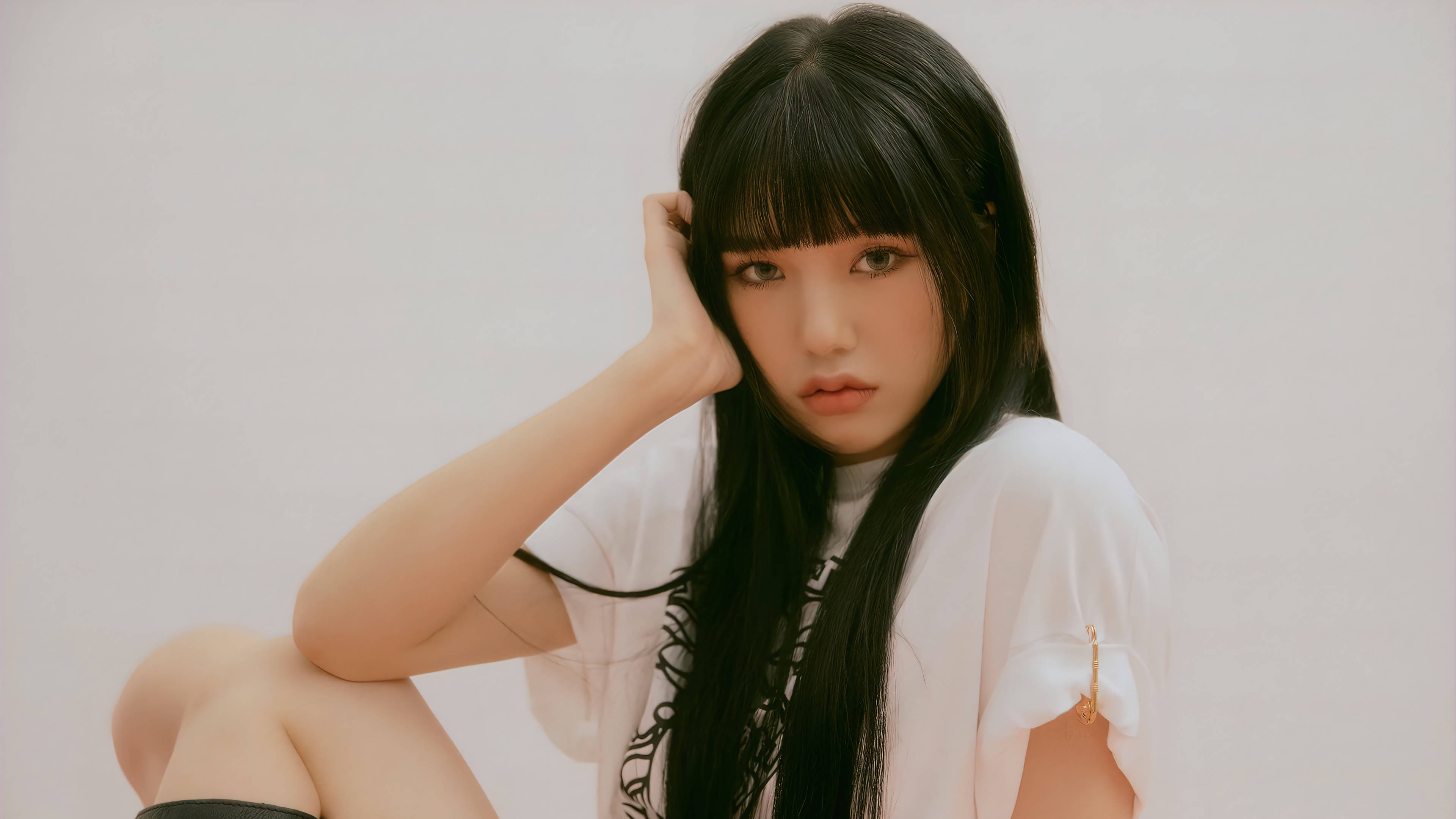 OH MY GIRL 主Rapper Mimi 壁紙 — 一位長黑髮的年輕女性坐在純白背景前，手放在頭部附近，直視鏡頭。