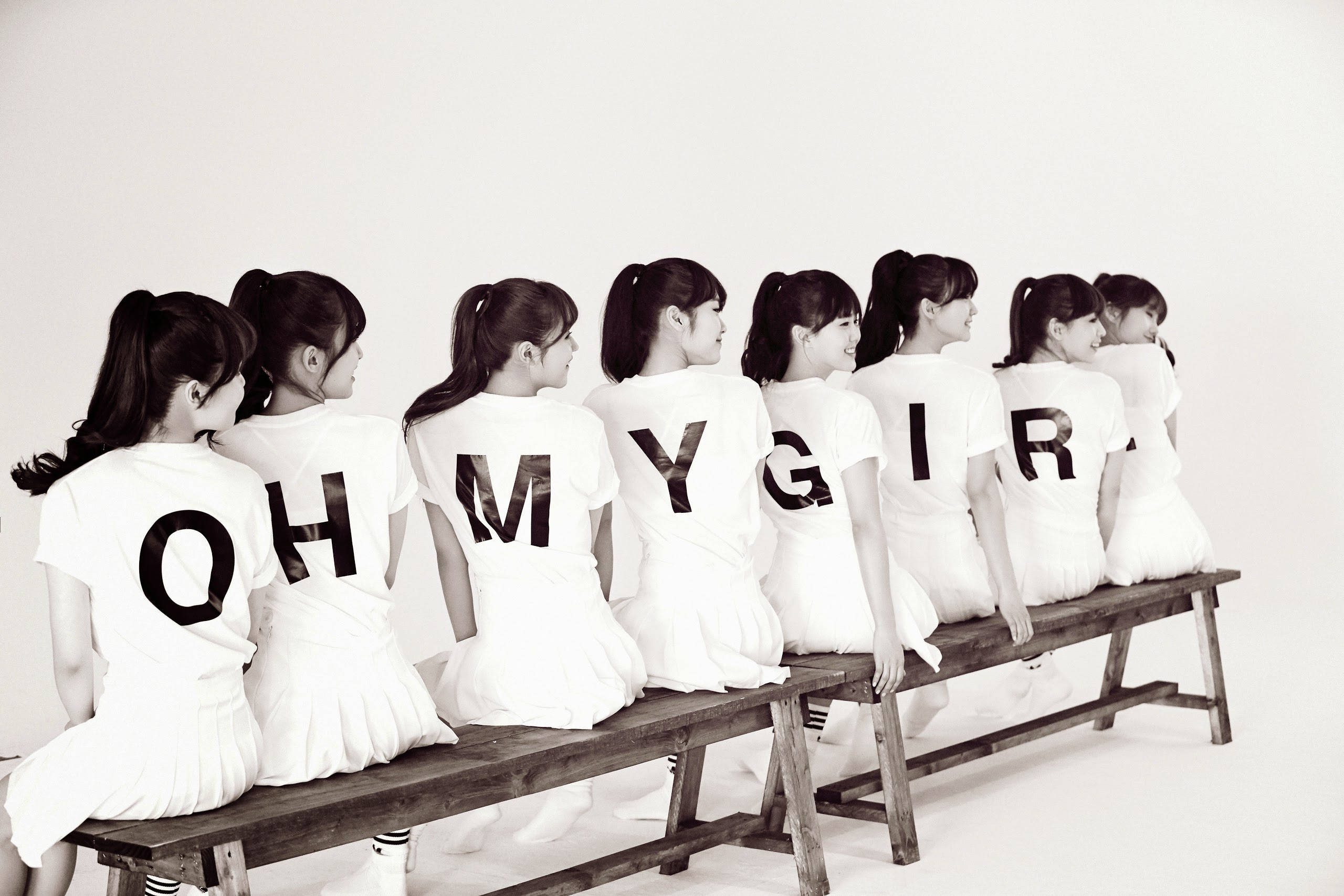 OH MY GIRL 白色服裝造型 壁紙 — 七名身穿白色服裝的女性坐在木長凳上排成一排，在純白色背景上背對背拼出「OH MY GIRL」。