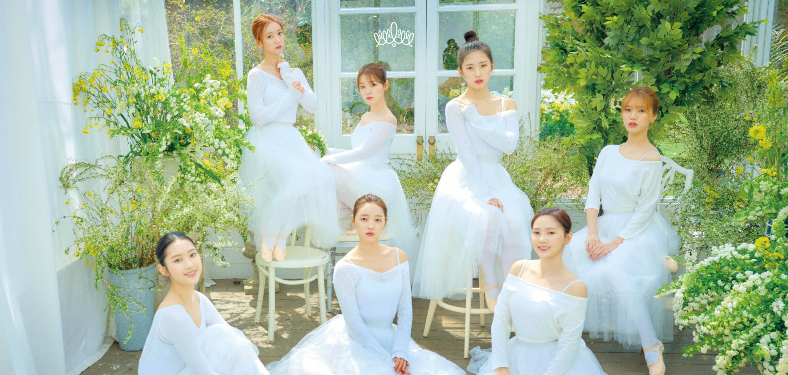 OH MY GIRL 身著白裙 壁紙 — 六位身穿飄逸白色連衣裙的女性在陽光普照的溫室中，於茂密的綠植和鮮豔的花朵間優雅地擺姿勢。