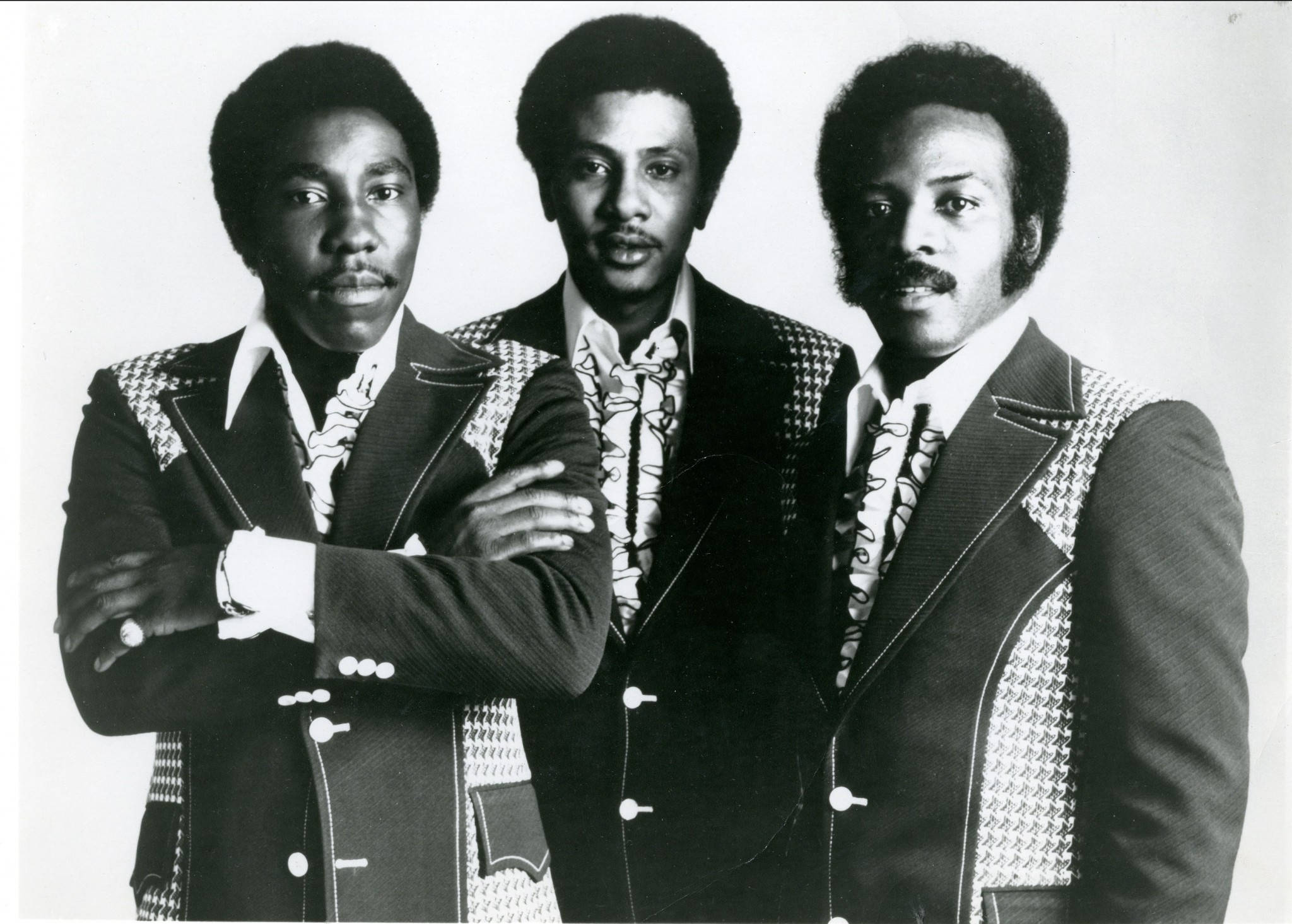 Ojays Eddie Levert 新音樂 壁紙 — 三位時尚男士身穿圖案西裝，在純色背景前自信擺姿勢，呈現經典黑白影樓肖像。