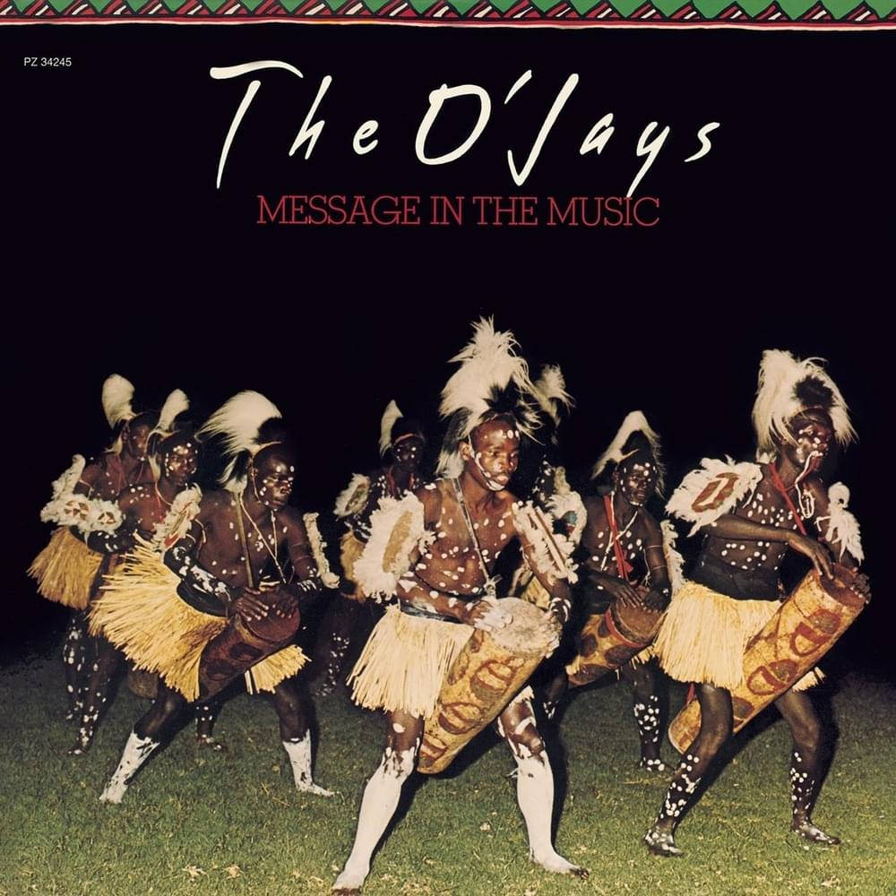 Ojays 參訪祖魯文化村 壁紙 — 一群穿著傳統羽毛頭飾和草裙的舞者在黑暗的天空下在草地上充滿活力地表演。