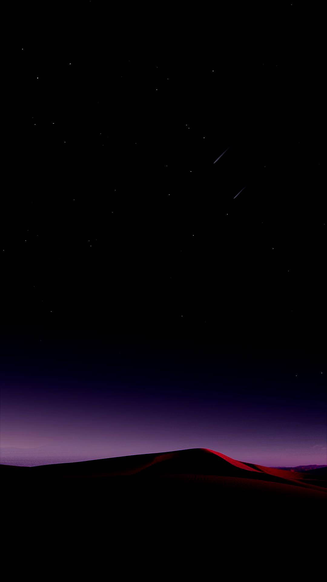 在繁星點點的夜空下，有兩顆流星的沙漠沙丘剪影。