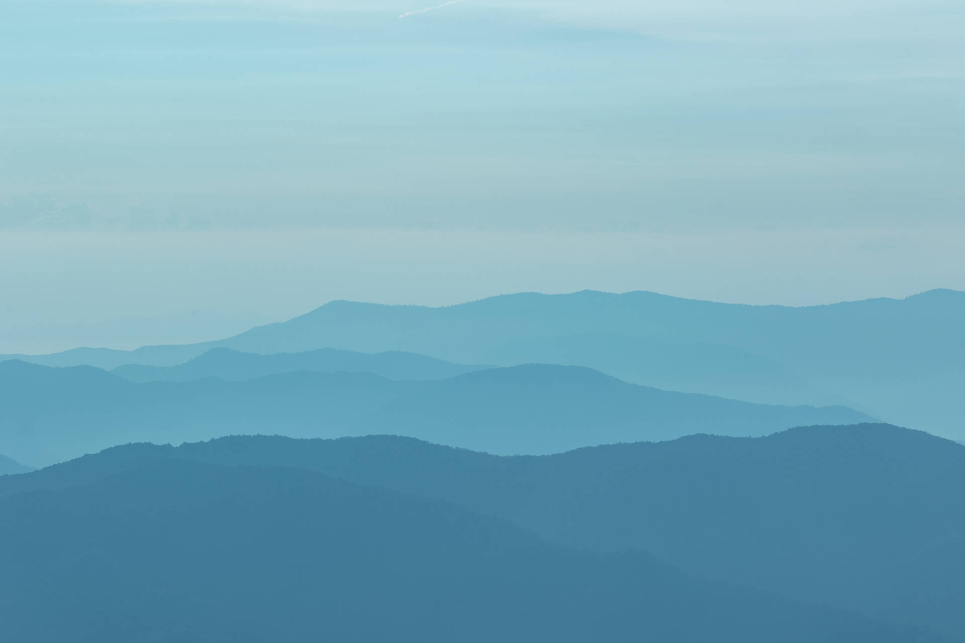 寧靜的山景，層次逐漸融入藍色霧靄。