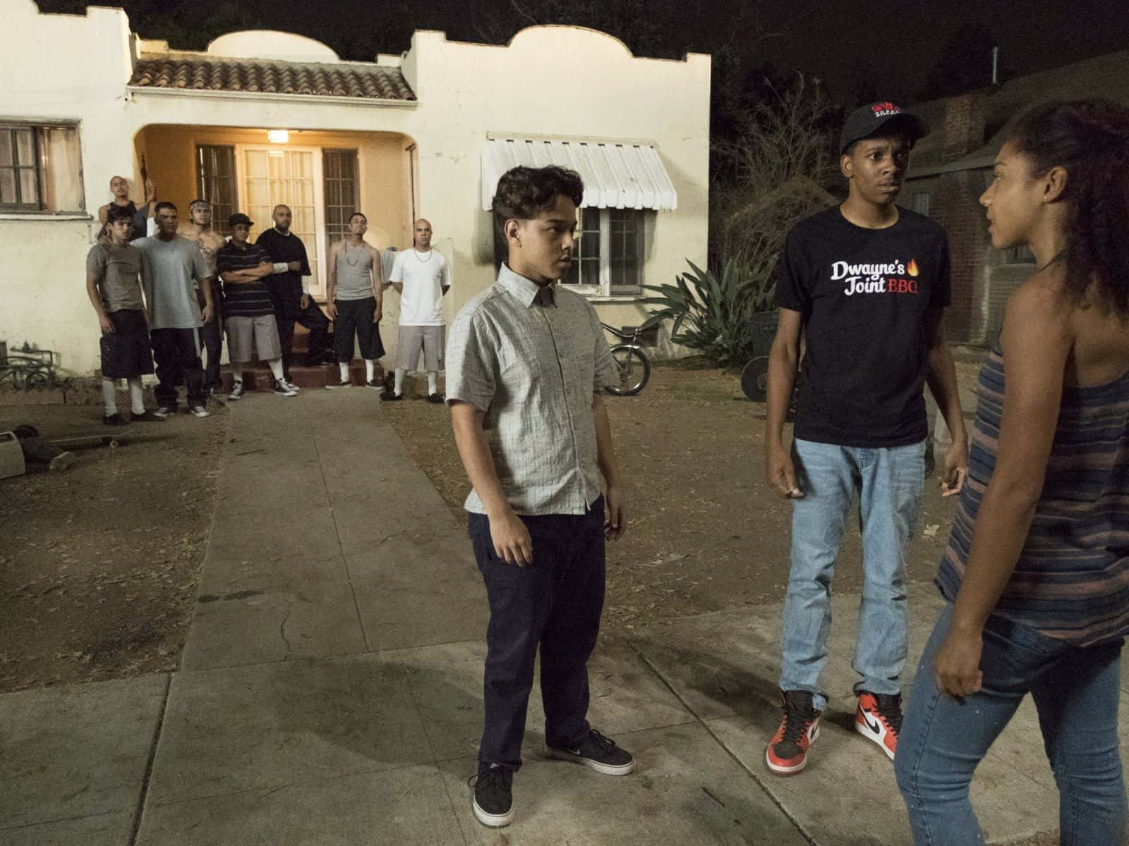 青少年在夜間於住宅區人行道上互相對峙。