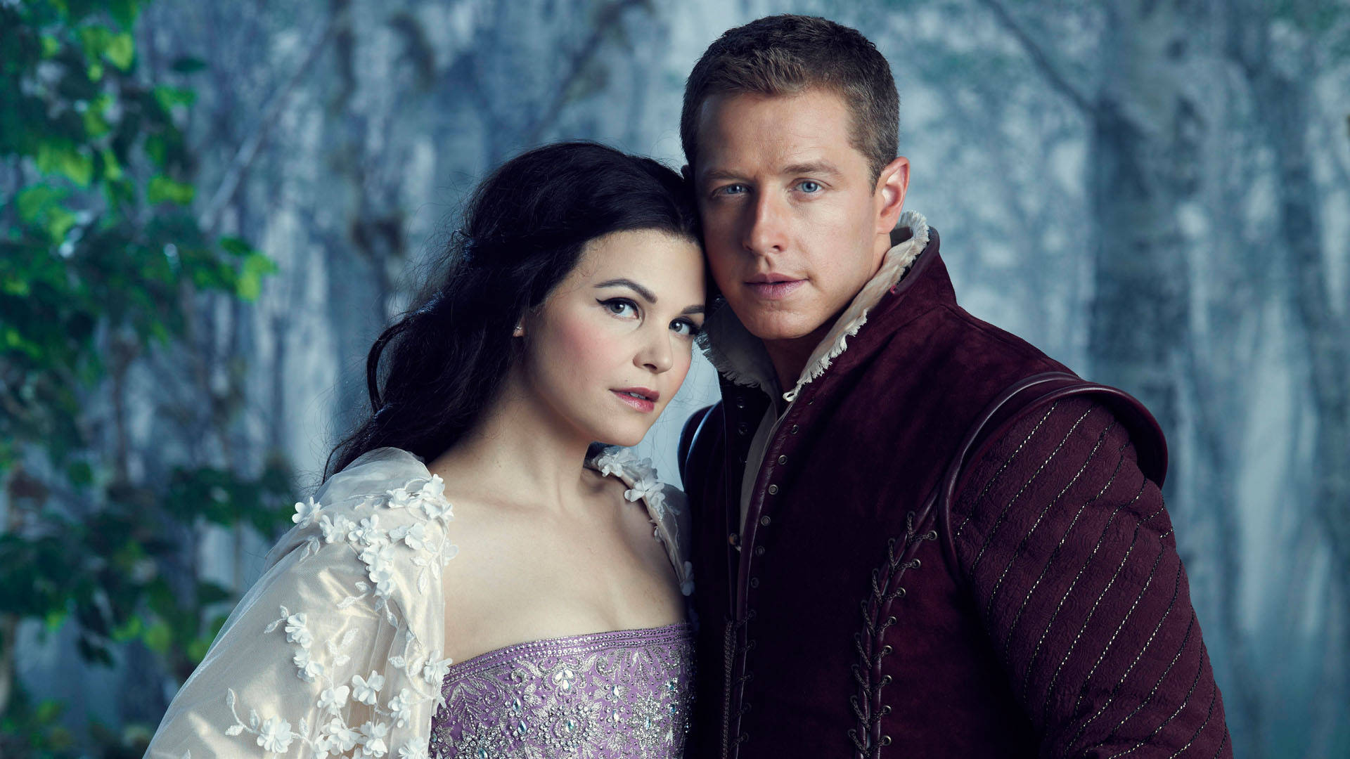 《Once Upon A Time》雪白與王子 壁紙 — 一名身穿古裝的男子和女子在霧氣瀰漫的森林中緊密站立，周圍是光禿的樹木和柔和的綠意。