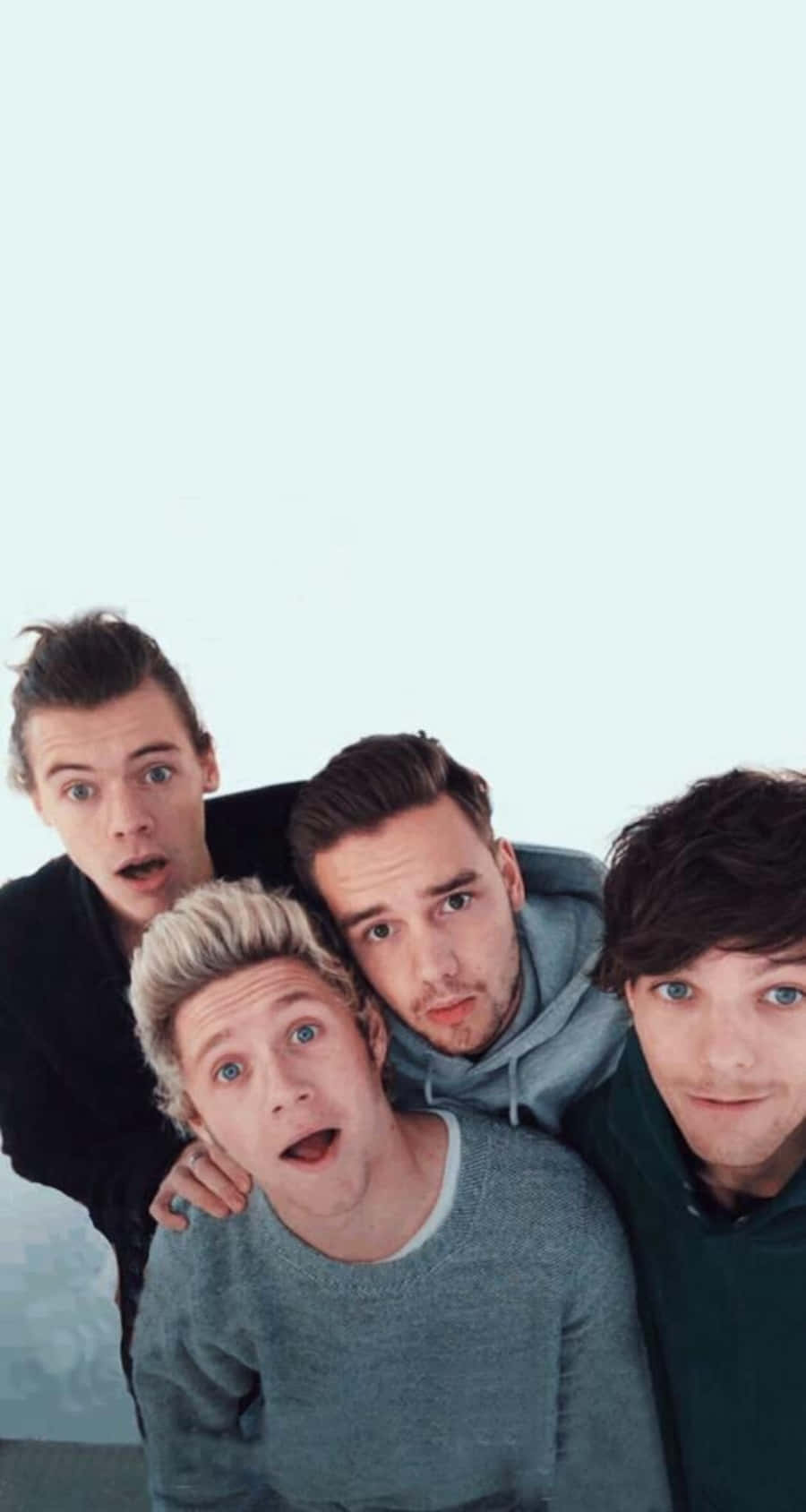 淡藍色背景 One Direction iPhone 壁紙 — 四位年輕男子帶著驚訝的表情，在淡藍色背景前緊靠在一起的自然照片。