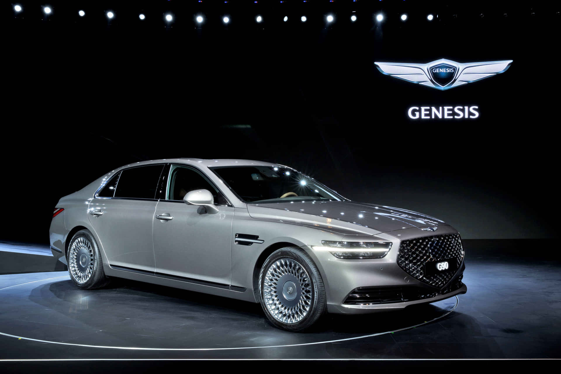 銀色Genesis G90豪華轎車在聚光燈下的舞台上。