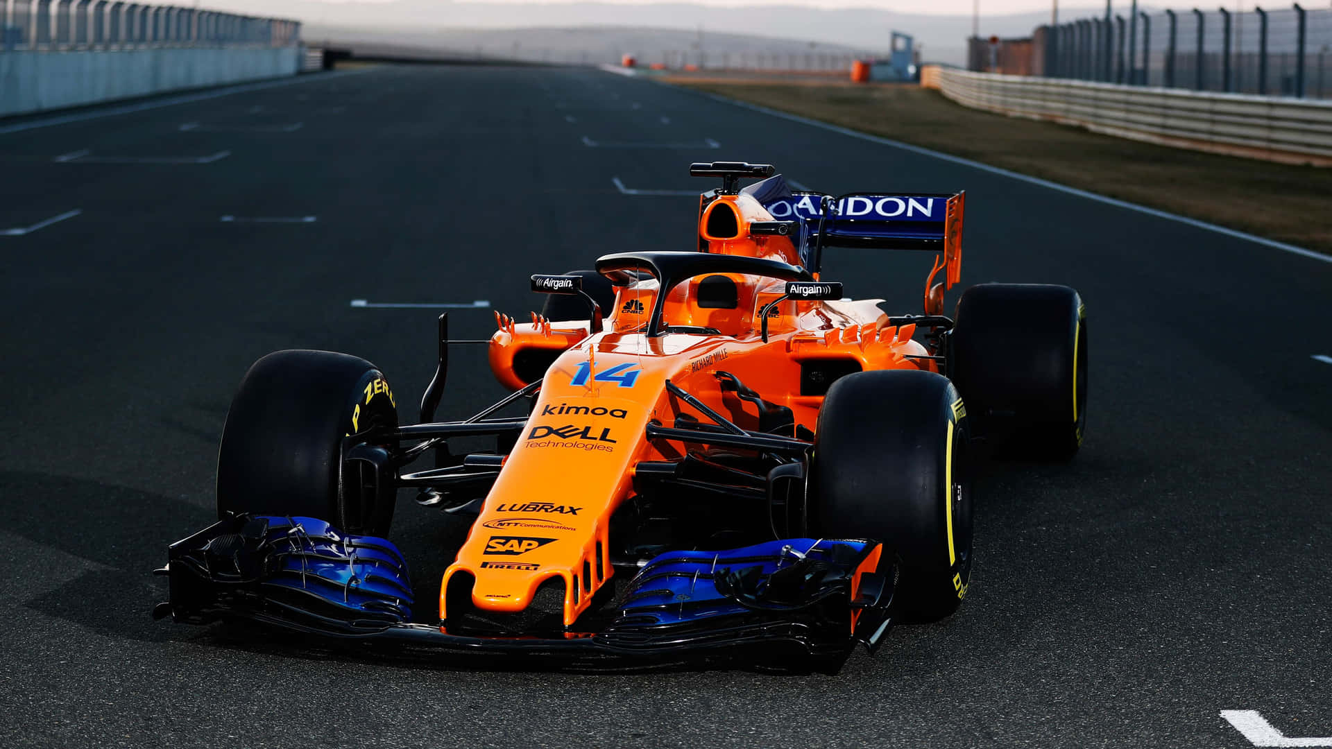 日落時分，賽道上的一輛橙色和藍色 Formula 1 賽車。