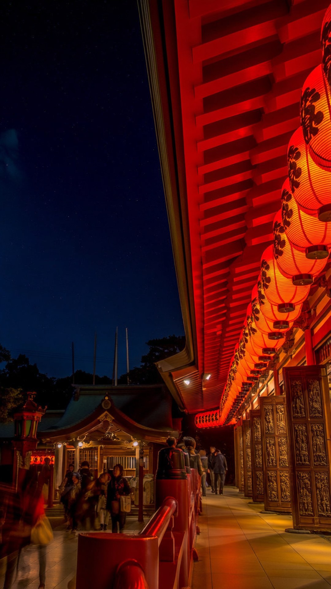 在星空下，日本神社的小路兩旁排列著紅色燈籠。