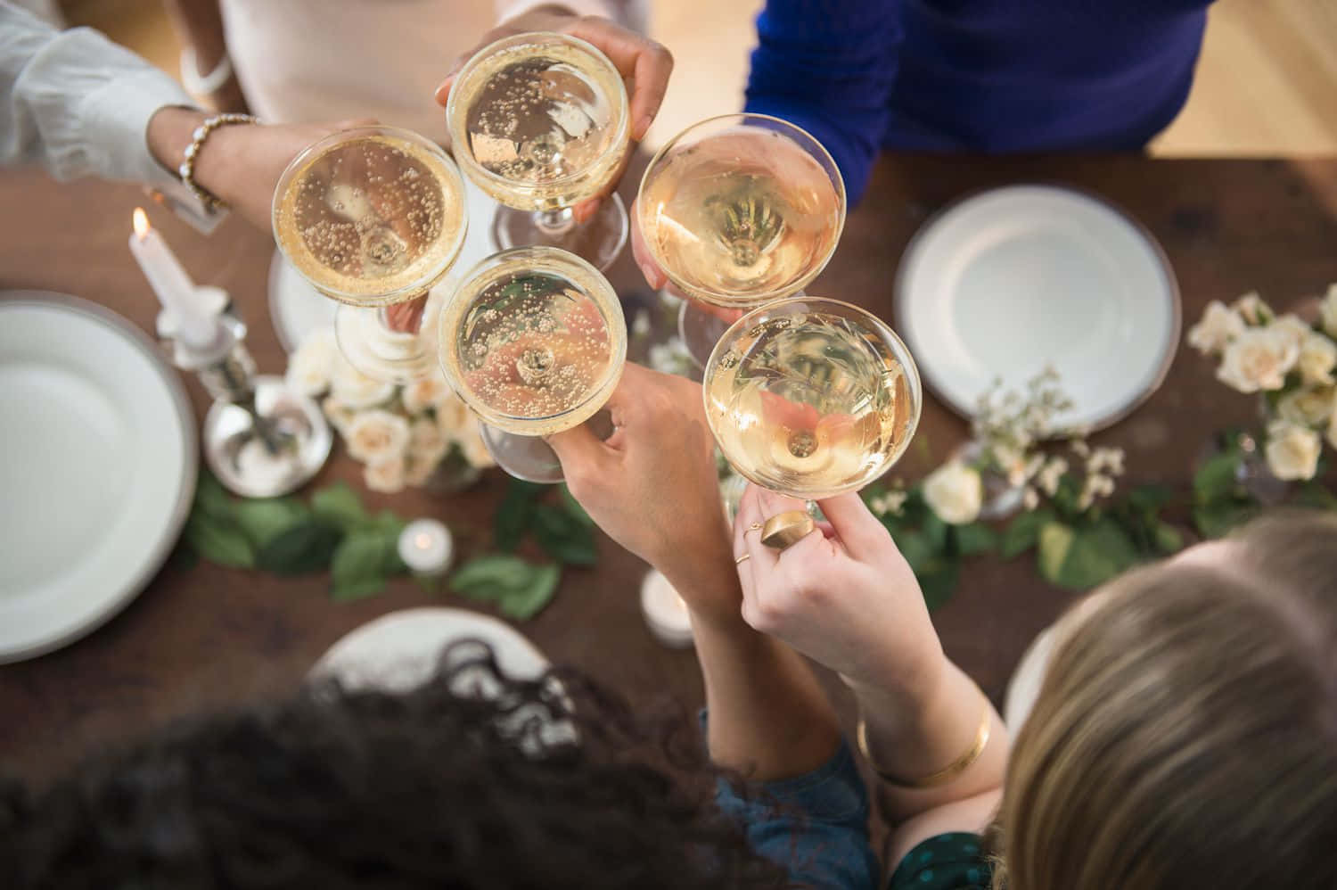 醉咗 桌布 壁紙 — Overhead view of friends clinking champagne glasses in a celebratory toast at a warmly lit dinner table.