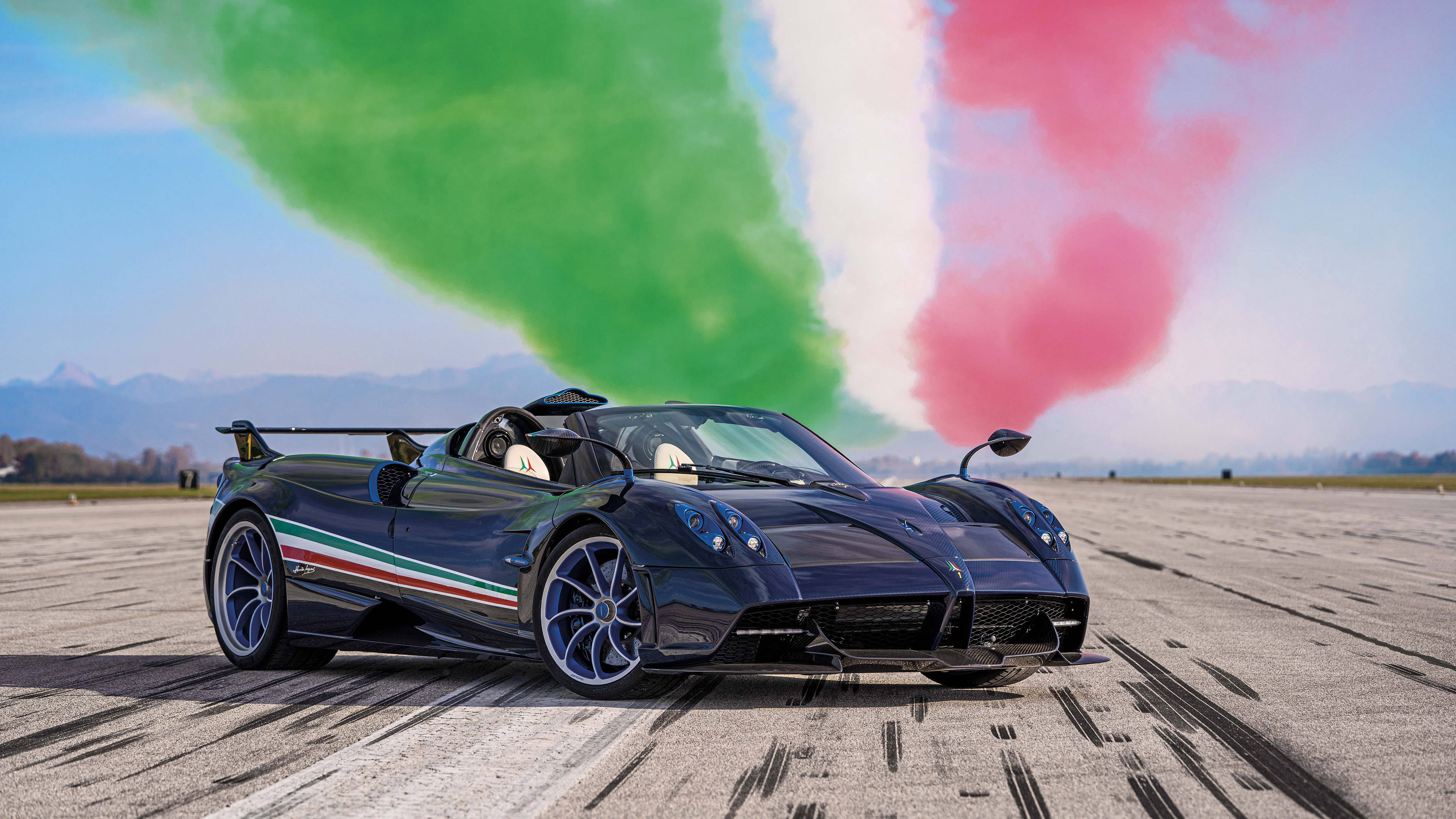 Pagani Huayra 超跑彩條裝飾 壁紙 — 一輛帶有意大利國旗塗裝的時尚黑色帕加尼Huayra跑車在跑道上留下輪胎痕跡，身後冒出綠色、白色和紅色的煙霧。