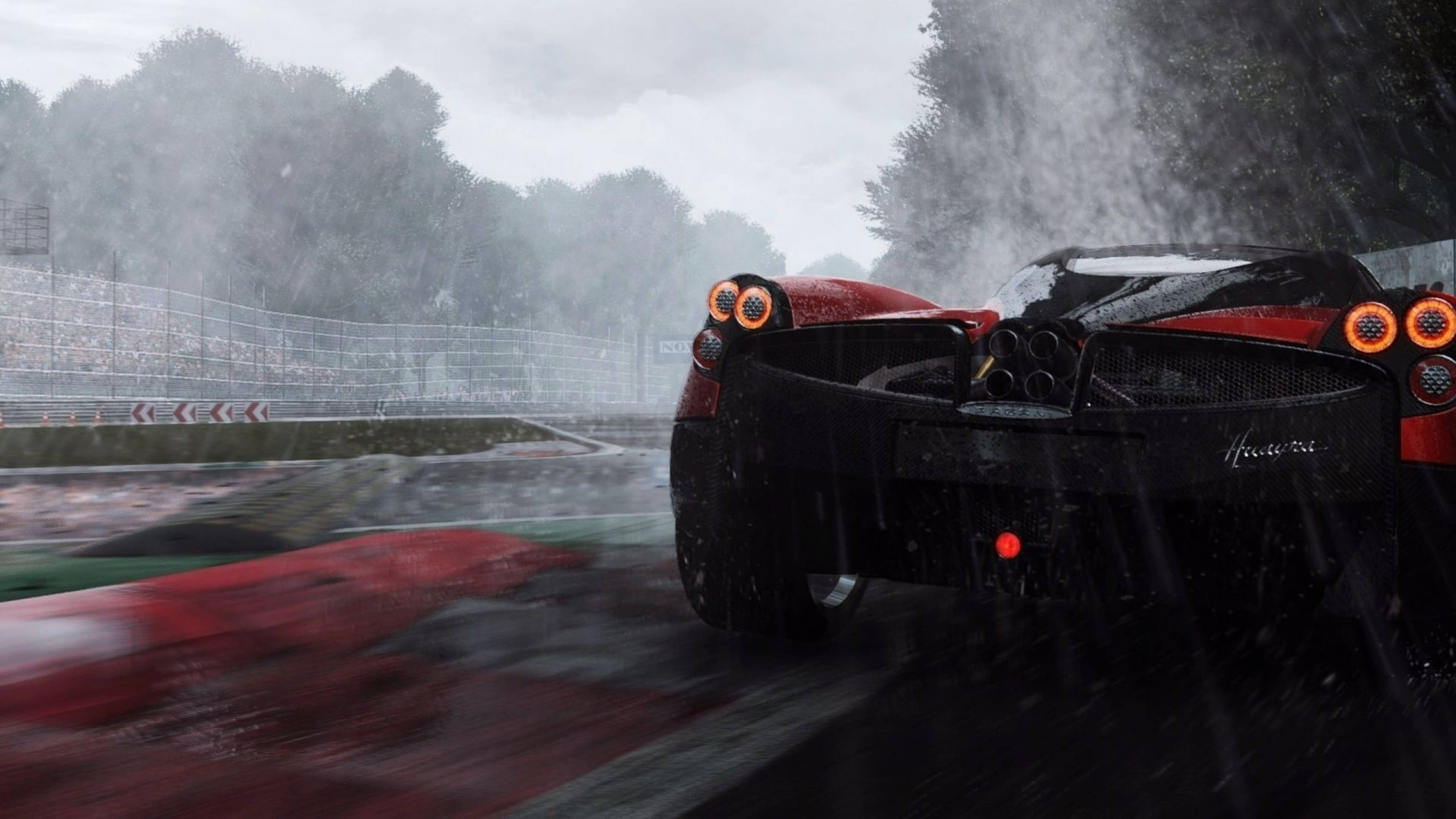 Pagani Zonda 雨中疾馳 壁紙 — 一輛紅色和黑色的法拉利 Huracán 在傾盆大雨中於潮濕的賽道上飛馳，背景霧氣瀰漫，樹木和看台模糊不清。