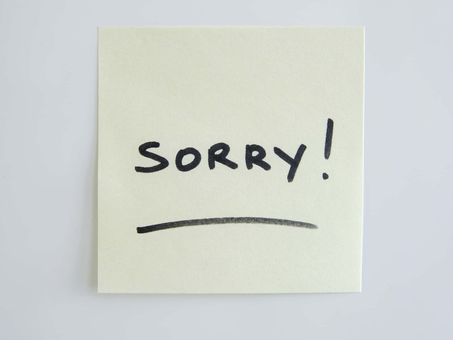  壁紙 — 一張淡黃色便利貼，上面用粗黑馬克筆寫著「SORRY!」，並有一條簡單的底線。