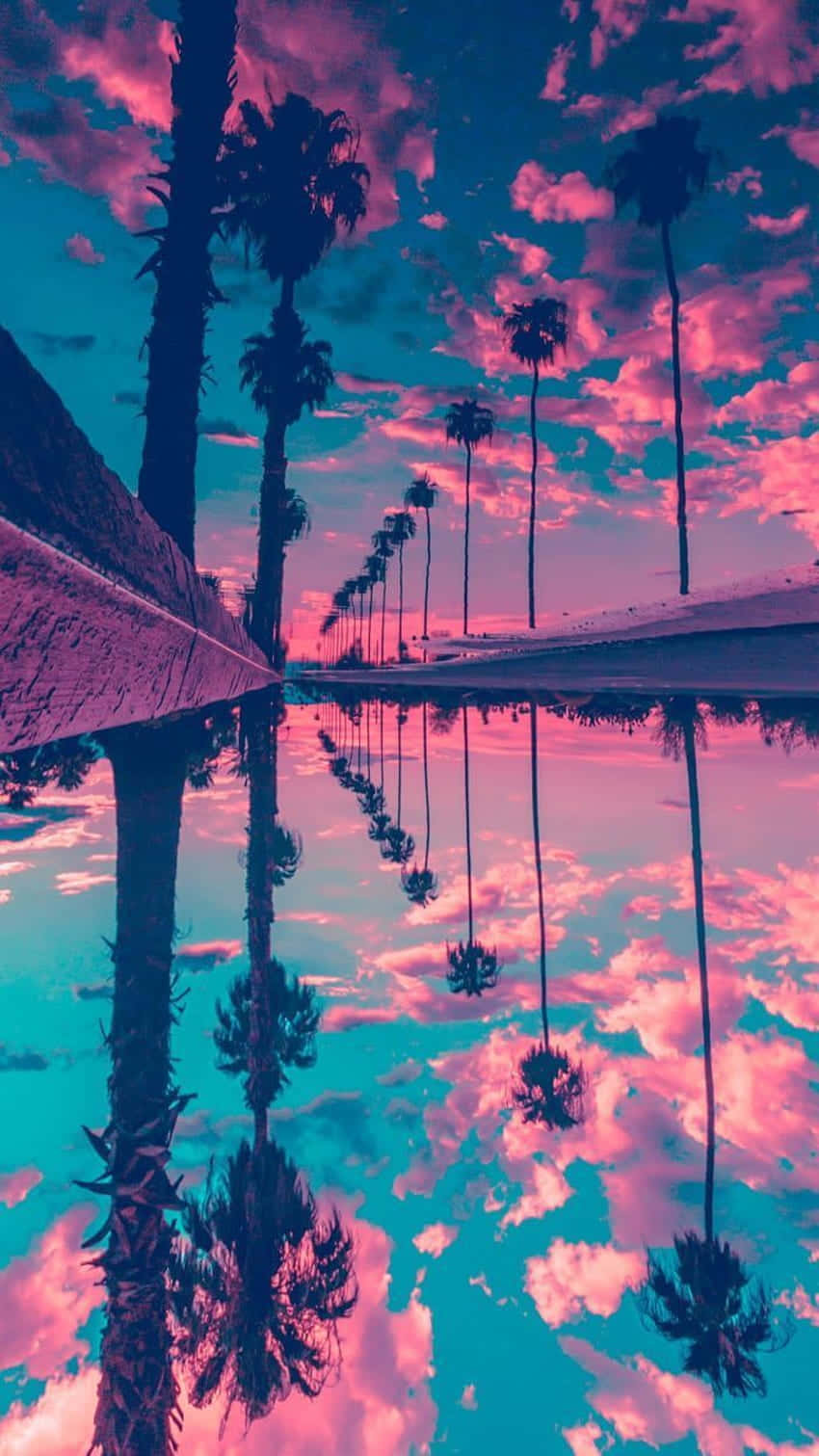  壁紙 — 棕櫚樹排列在反射池旁，上方是超現實的粉紅與藍綠色天空，完美倒映在水中。