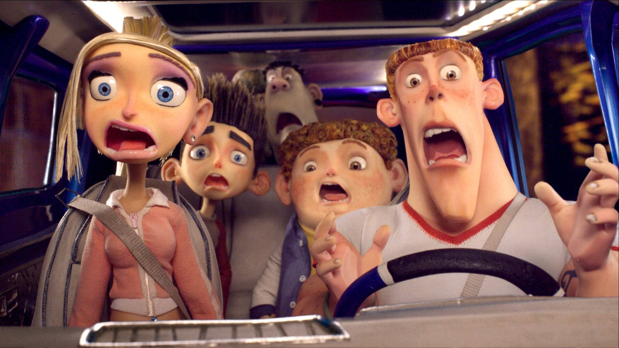 ParaNorman 角色在車內 壁紙 — 五個睜大眼睛的動畫角色在藍色車內於混亂行駛中驚恐尖叫。