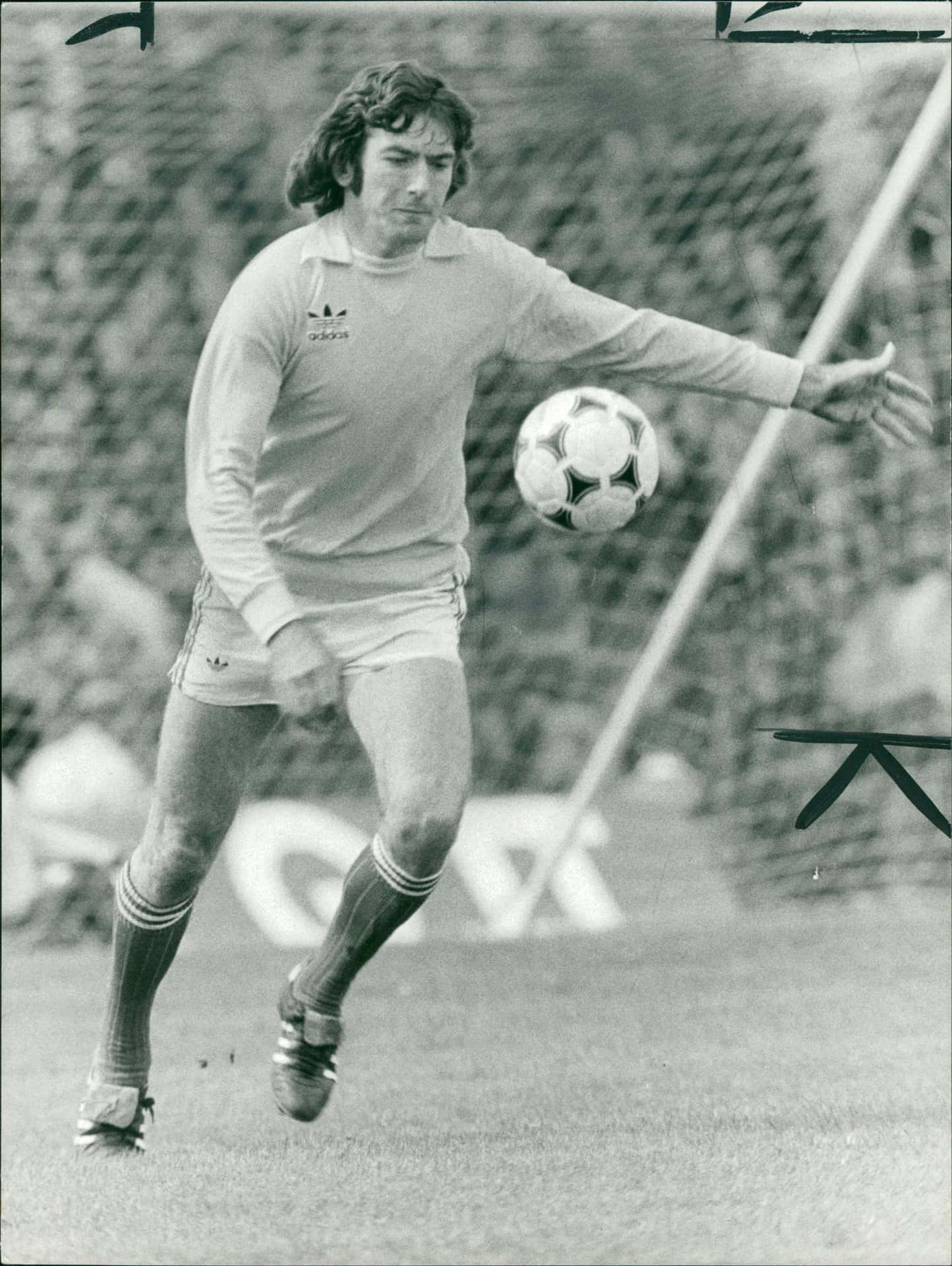 Pat Jennings 於 1979 年對陣英格蘭比賽 壁紙 — 一張復古黑白照片，足球運動員在草地上用經典Adidas球進行中踢動作。