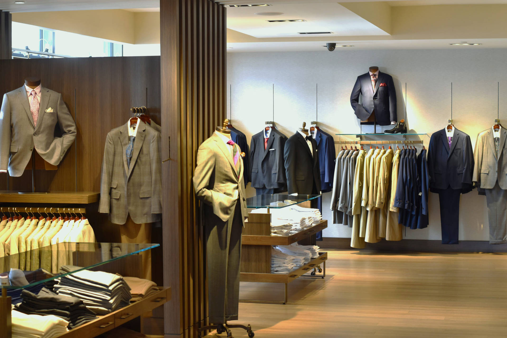 高級男裝店，西裝展示在模特兒和衣架上。