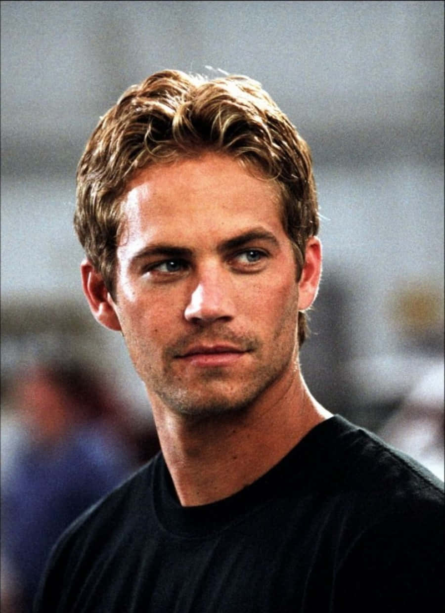 Paul Walker 桌布 壁紙 — Paul Walker 的 close-up 肖像，一頭凌亂金髮和深邃藍眼睛，身穿黑色 T 恤。