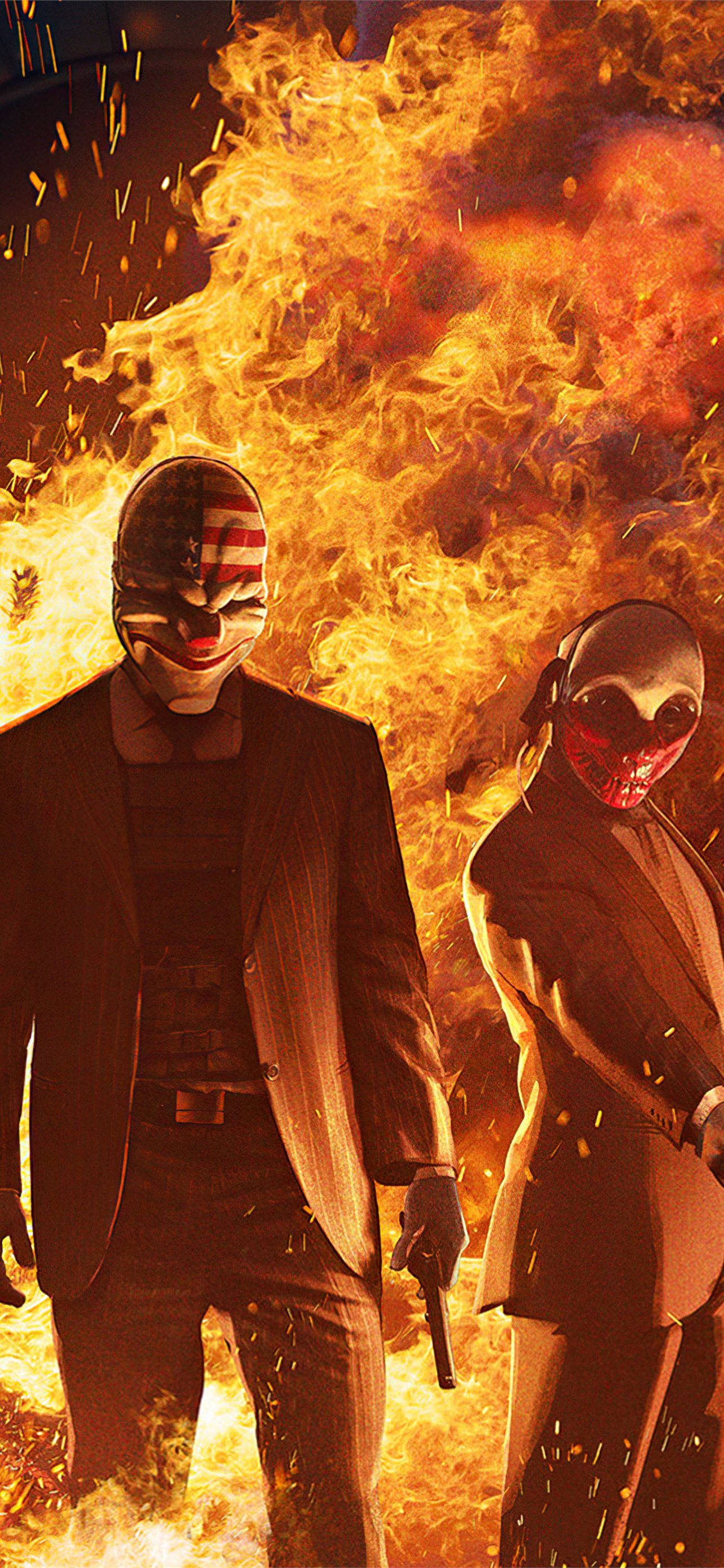 《Payday 2》遊戲達拉斯與狼置身火場 壁紙 — 兩個戴面具、身穿西裝的人物在戲劇性的火焰場景中，挑釁地站在咆哮的火焰和飛舞的火花之中。