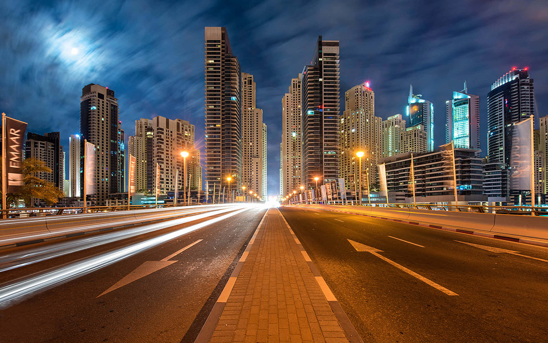 夜間城市景觀，高速公路上的光跡，明亮的月亮。