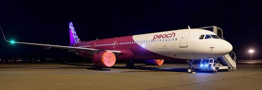 Peach Airlines飛機夜間停泊在停機坪上，燈光閃耀