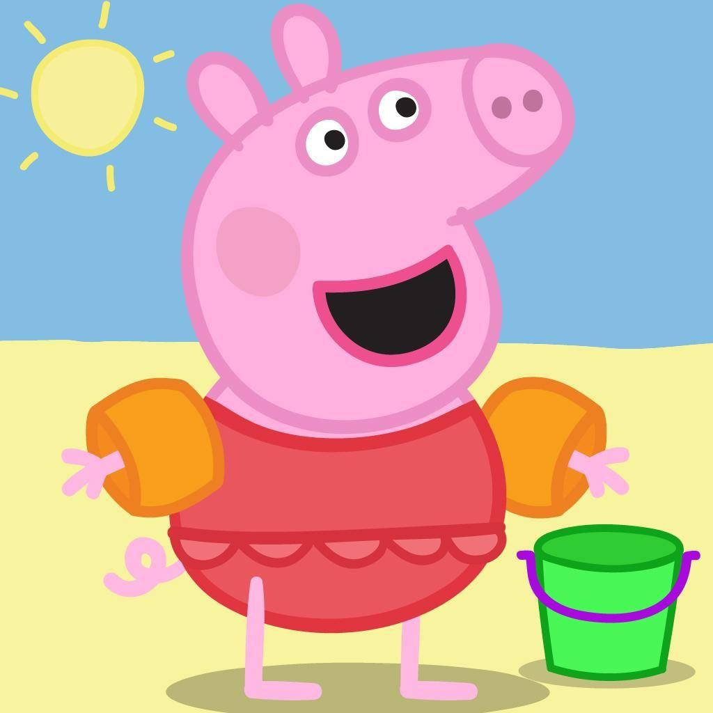 小豬佩奇 桌布 壁紙 — Peppa Pig 喺陽光海灘上，著住紅色泳衣同橙色浮水袖，喺綠色水桶旁邊開心咁笑。