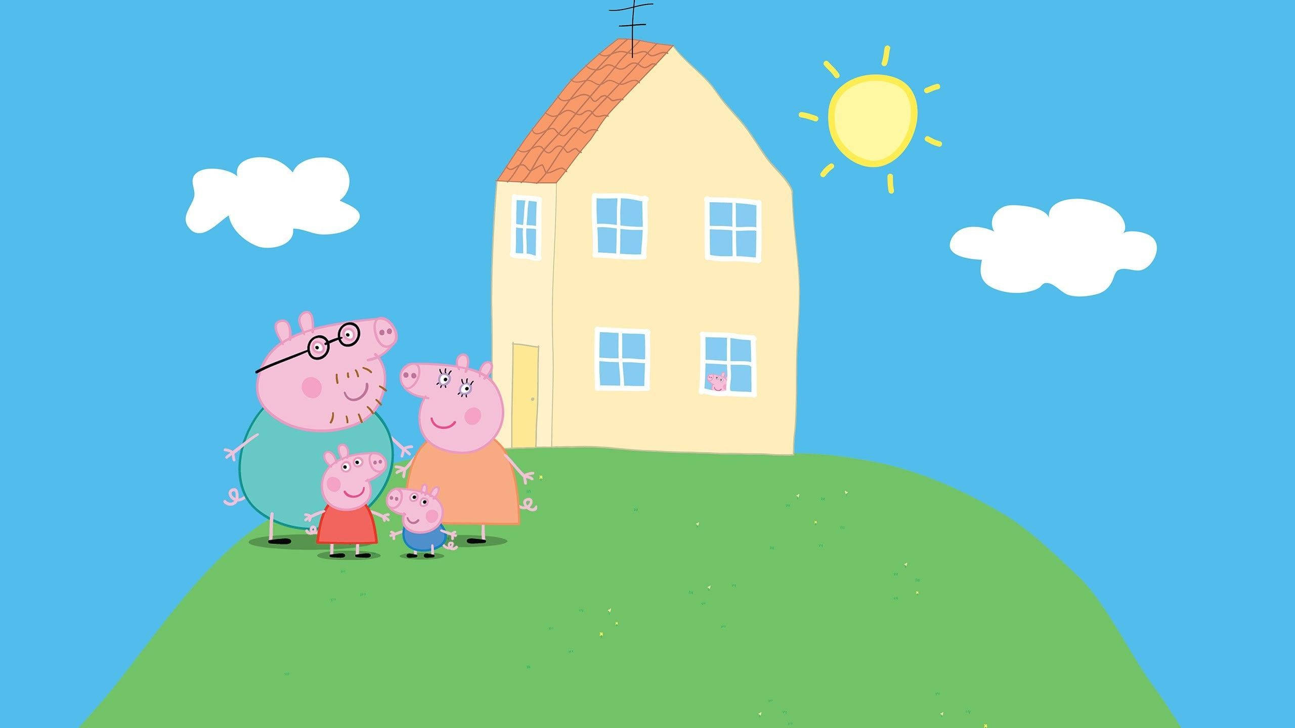 《Peppa Pig》家庭卡通頻道角色 壁紙 — Peppa Pig 一家在陽光和雲朵的明亮藍天下，站在黃色房子前的綠色山丘上微笑。